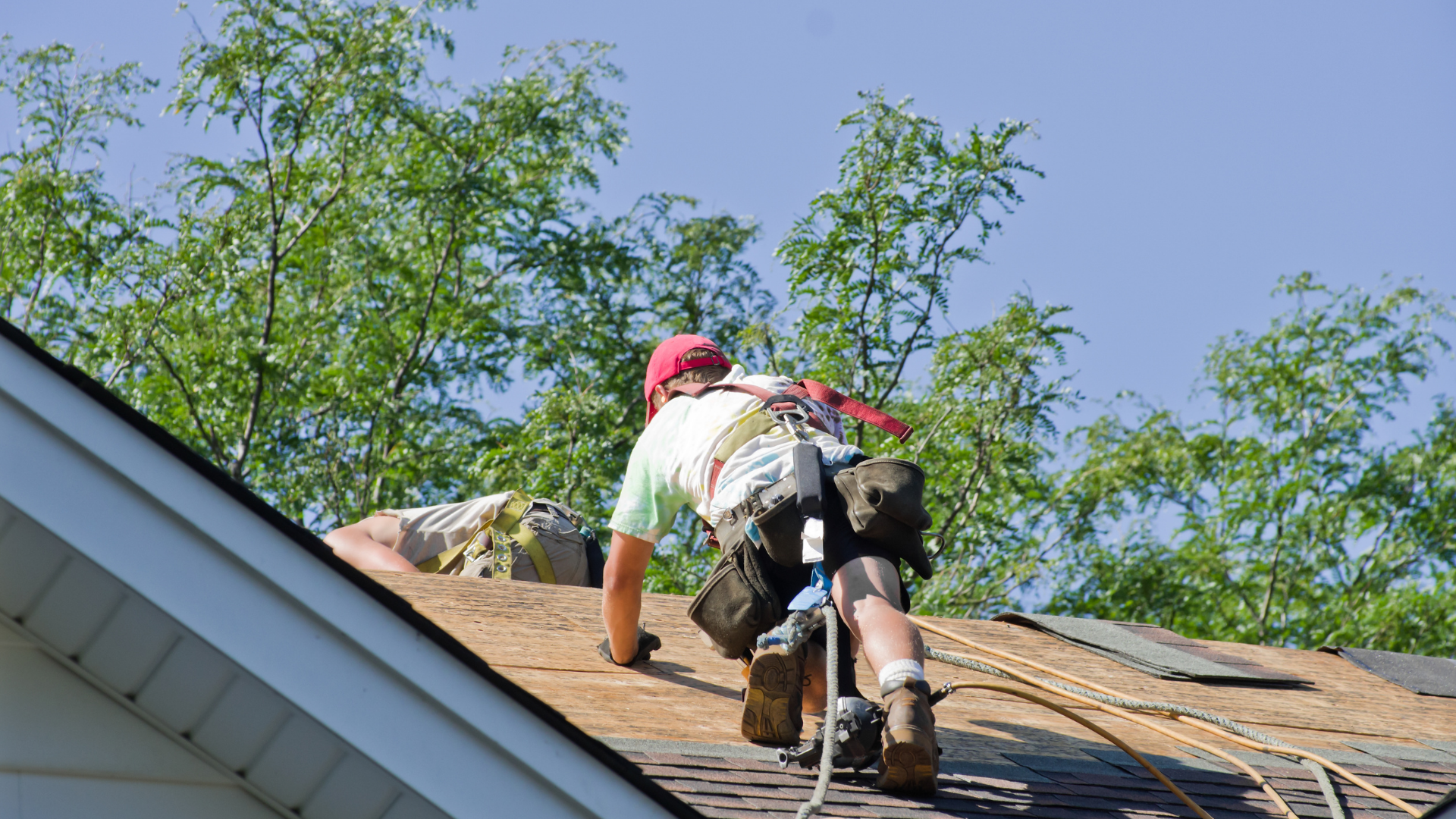 A man climbing in the roof with safety rope.