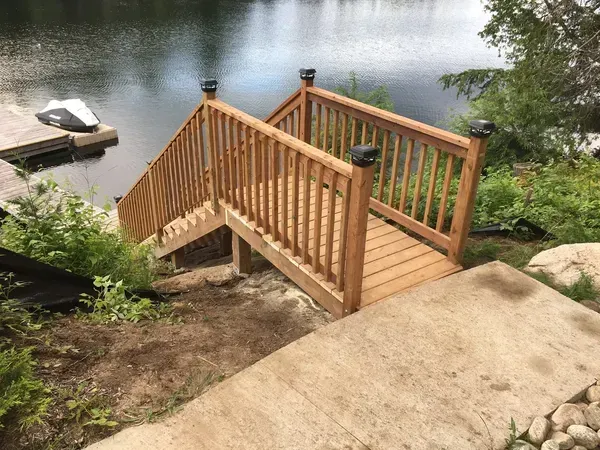 A wooden bridge over a lake with stairs leading up to it.
