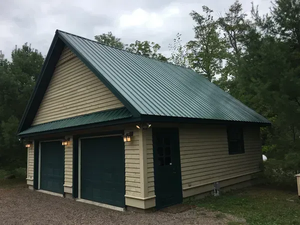 A garage with a green roof and two garage doors
