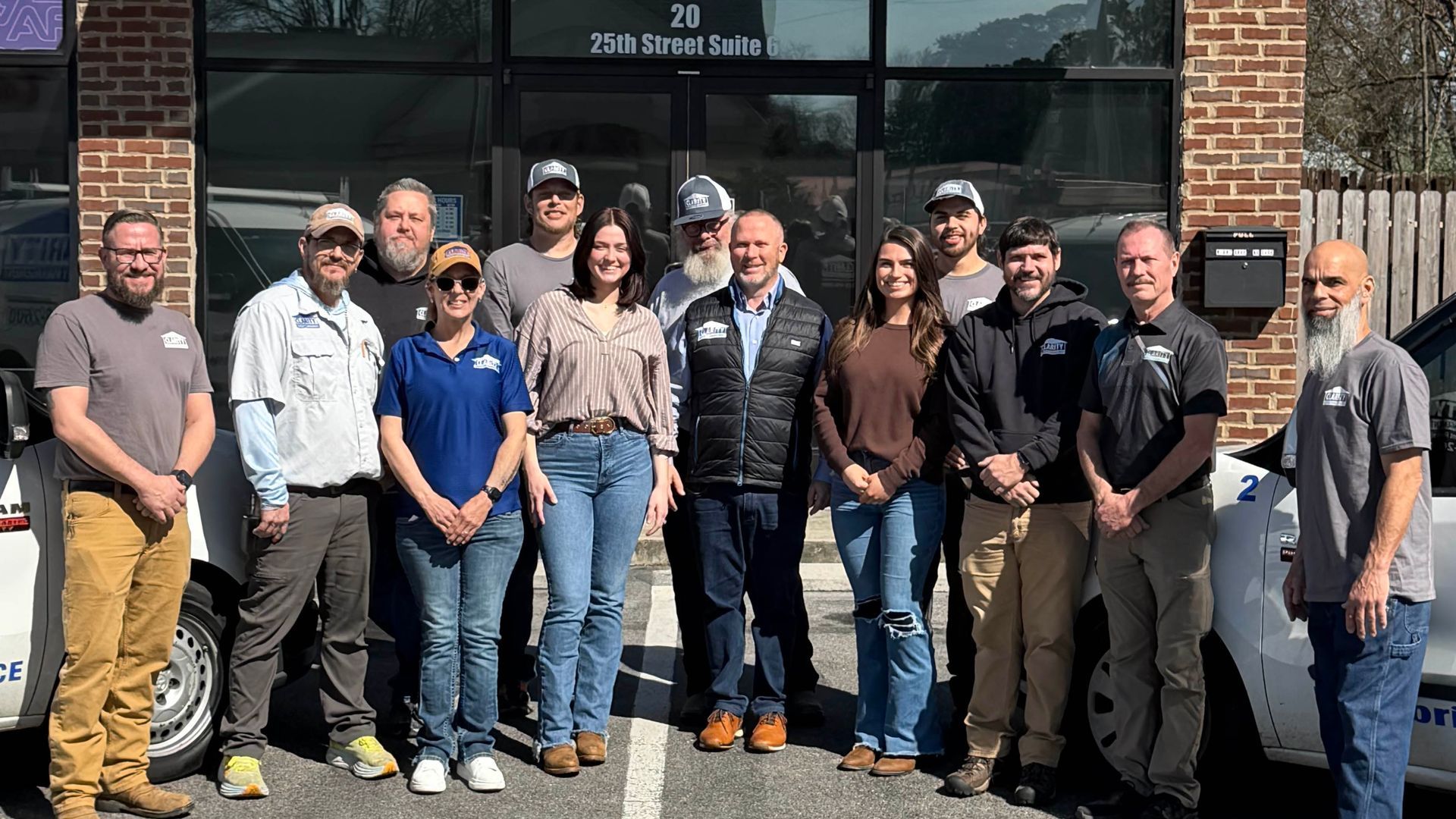 Person using a drill to install a part on a wooden surface, wearing green work gloves.