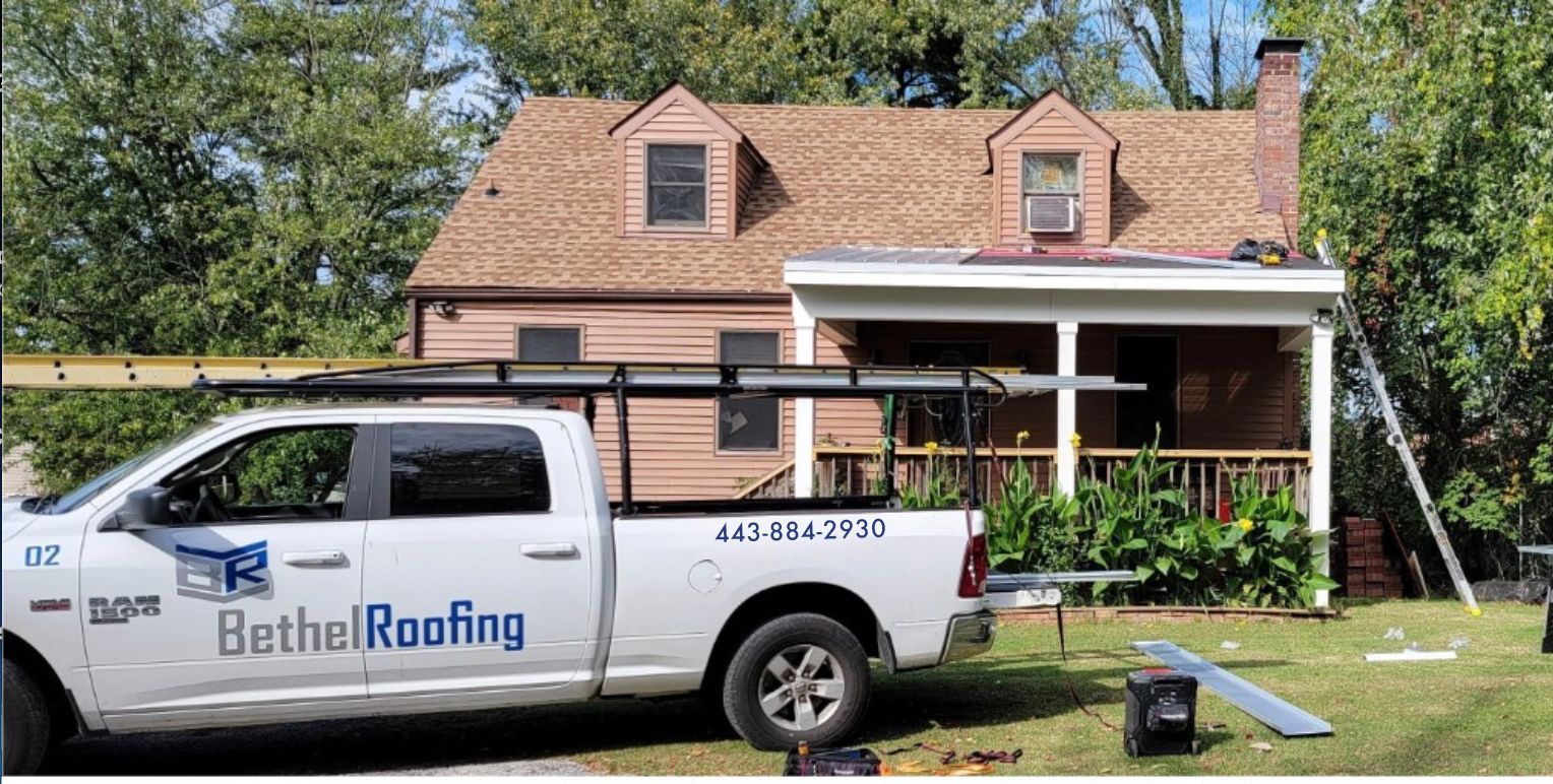 A man is working on the roof of a house with a skylight