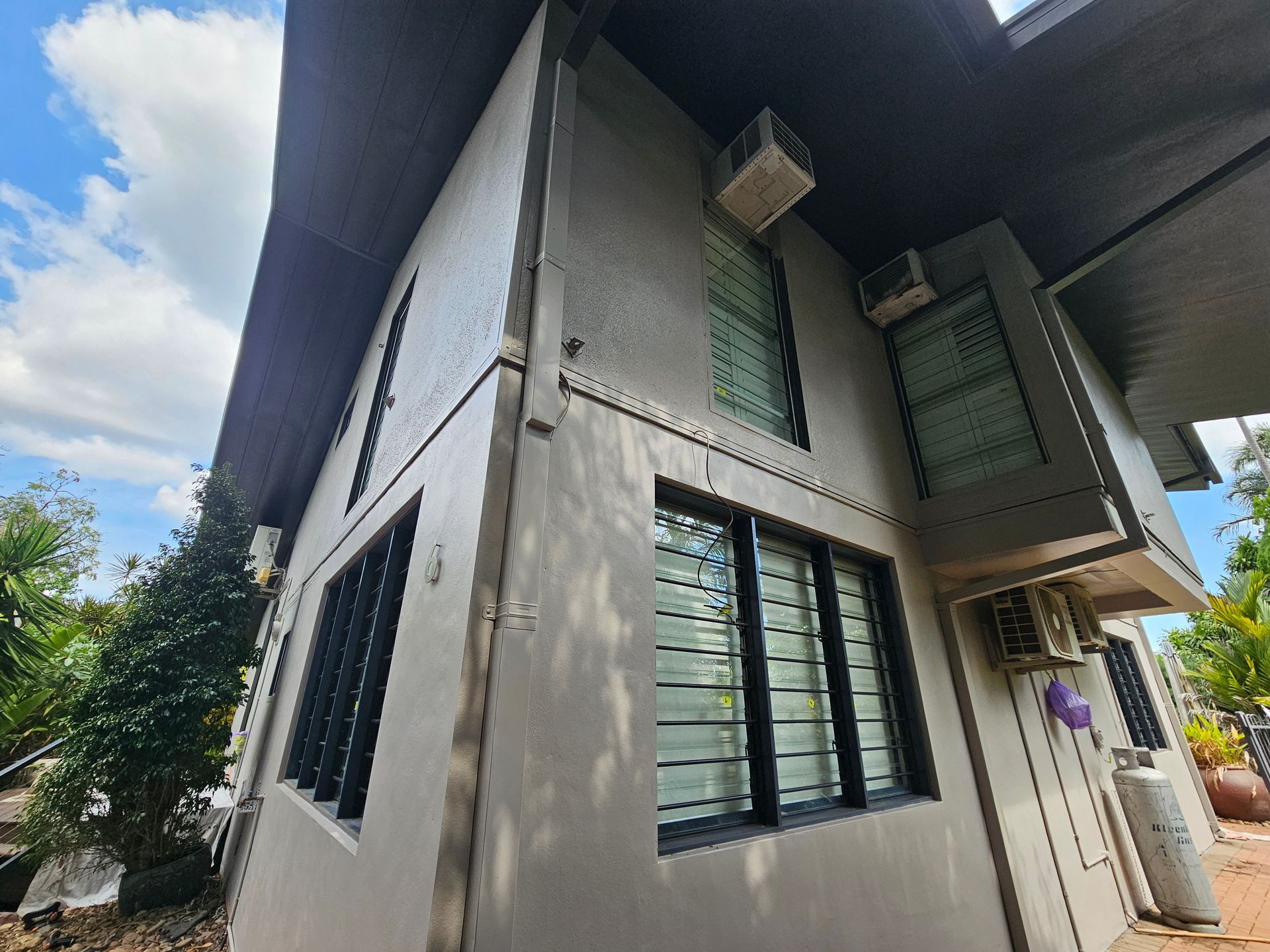 Two-story House With Grey Walls, Black-framed Windows, and Air Conditioning — Prestige Painting NT in Zuccoli, NT