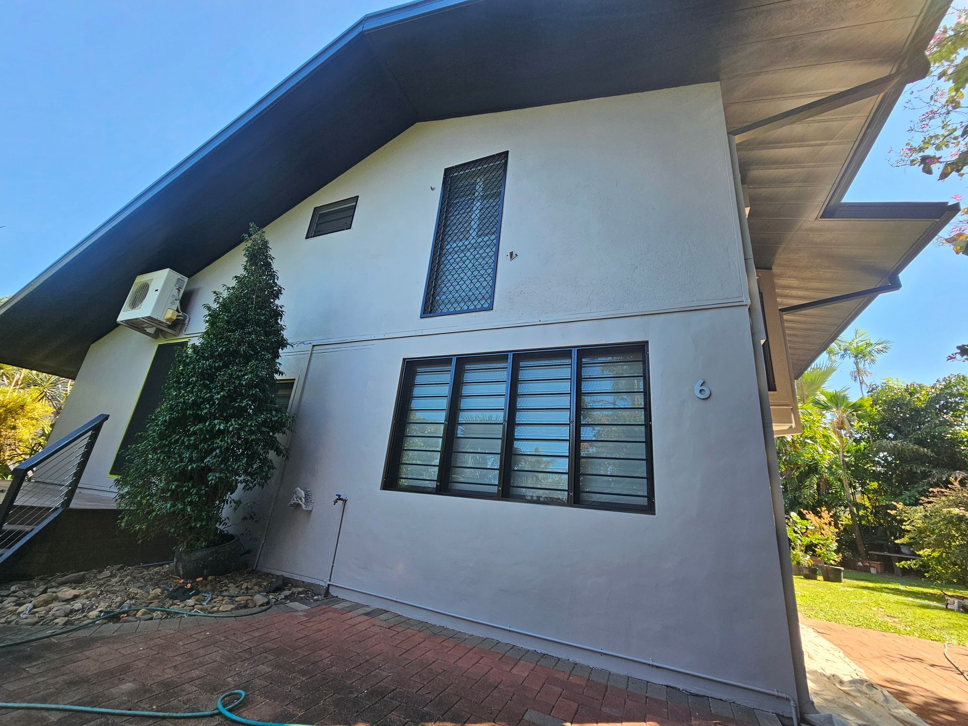 Grey building with angled roof, three windows, and air conditioning unit. — Prestige Painting NT in Zuccoli, NT