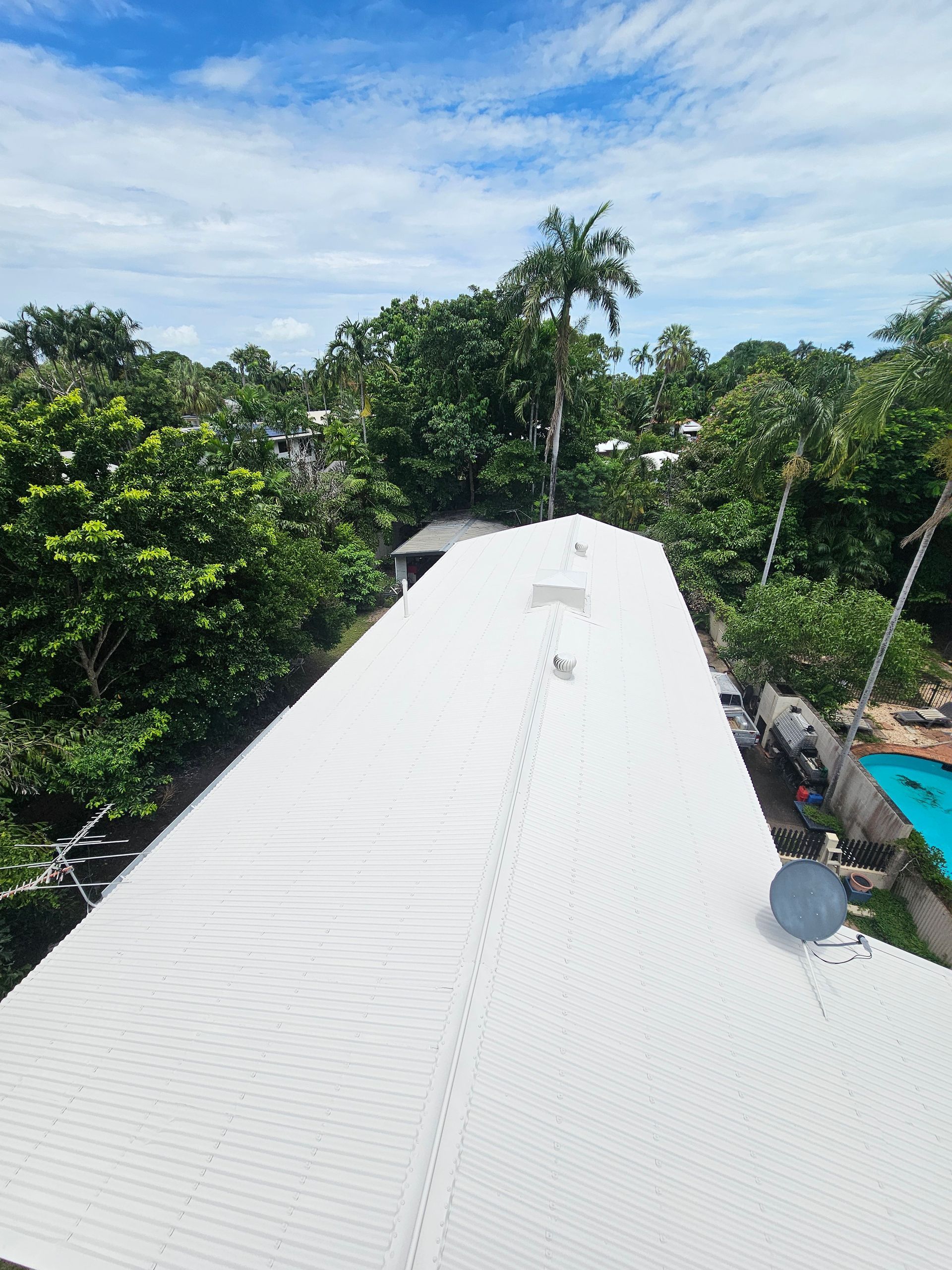 White Corrugated Metal Roof Surrounded by Lush Green Trees and Foliage — Prestige Painting NT in Zuccoli, NT