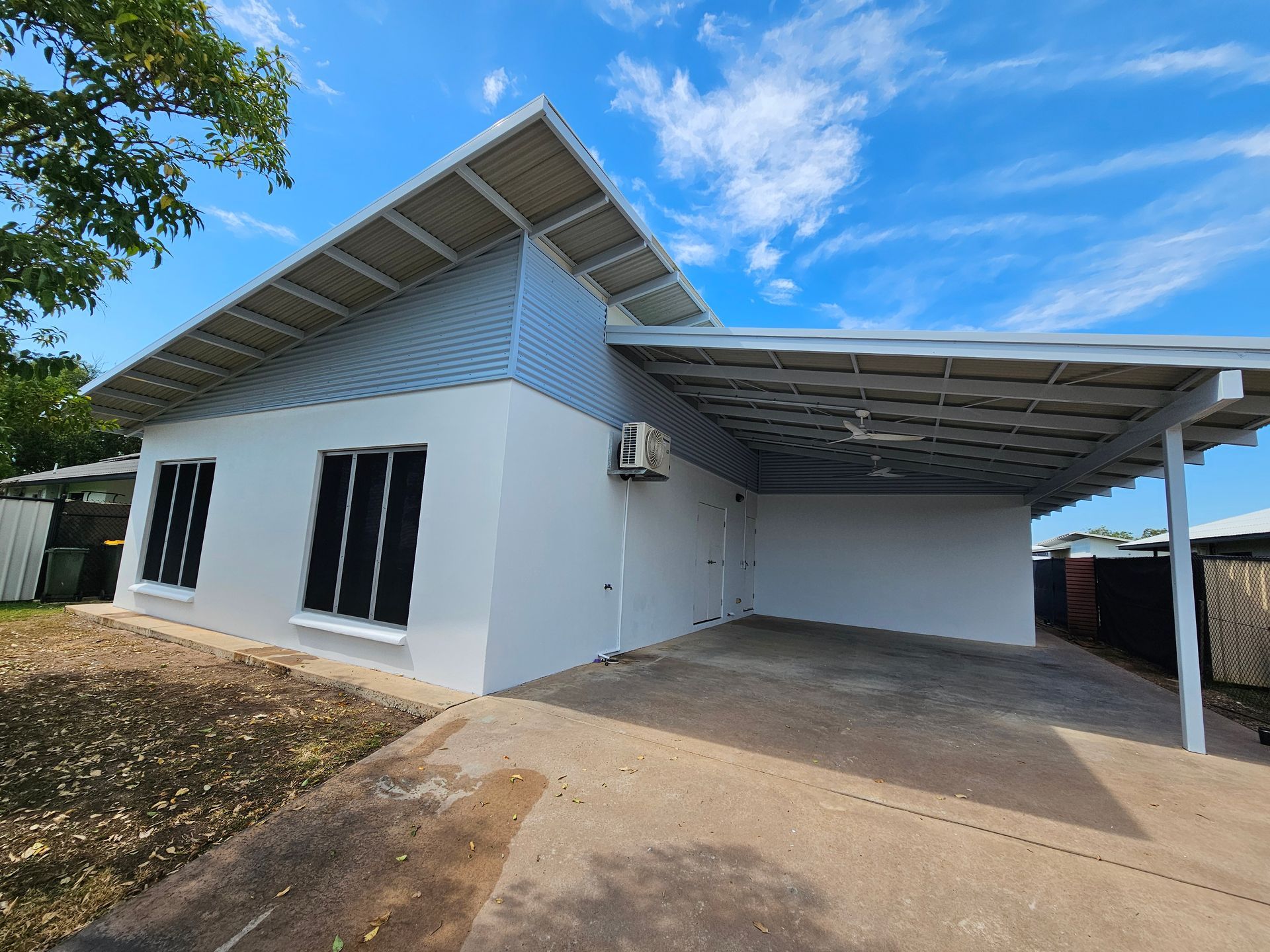 White House With Angled Roof and Carport Under a Blue Sky — Prestige Painting NT in Zuccoli, NT