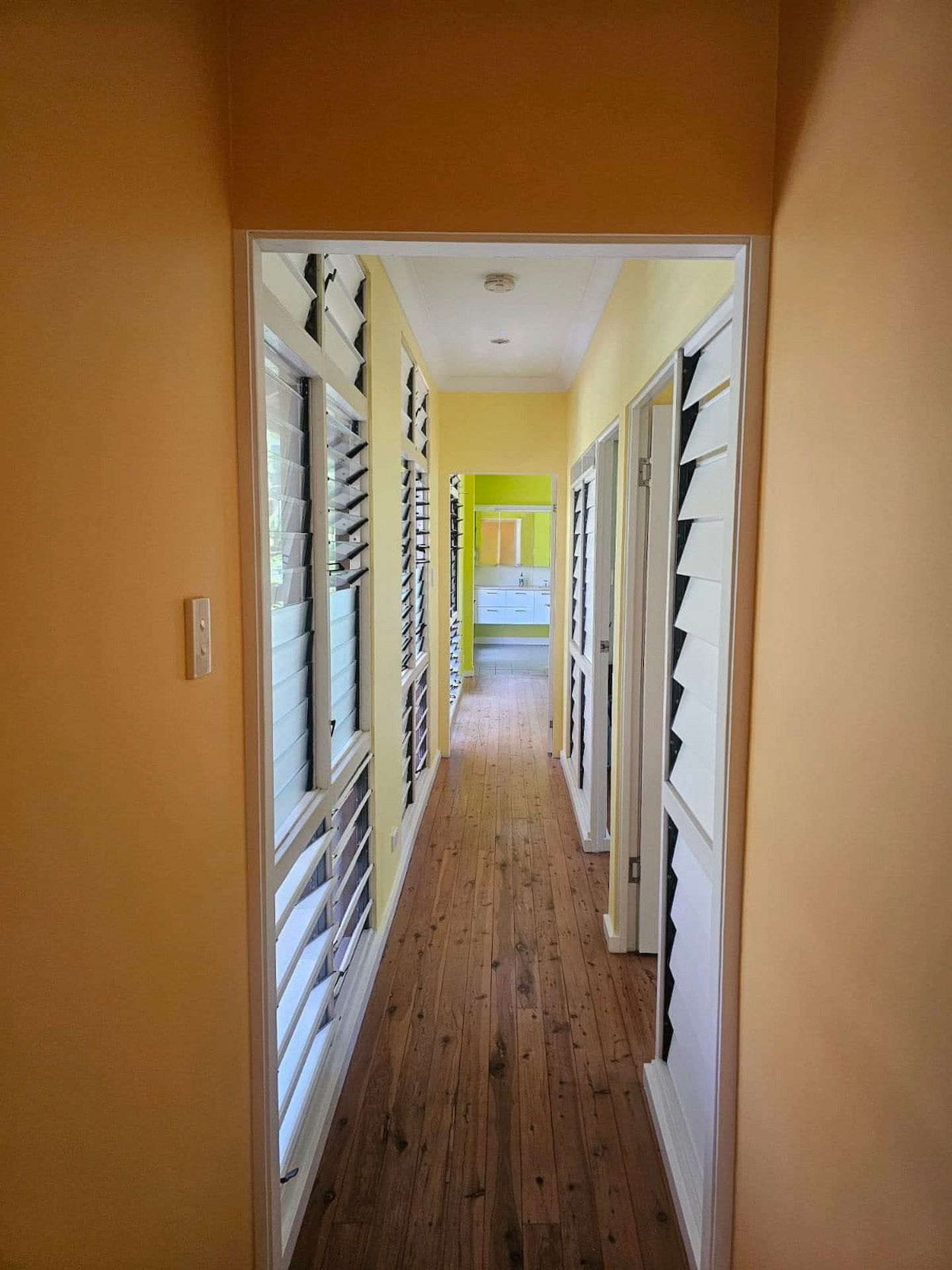 Narrow Hallway With Wooden Floor and Yellow Walls, Doors and Windows — Prestige Painting NT in Zuccoli, NT