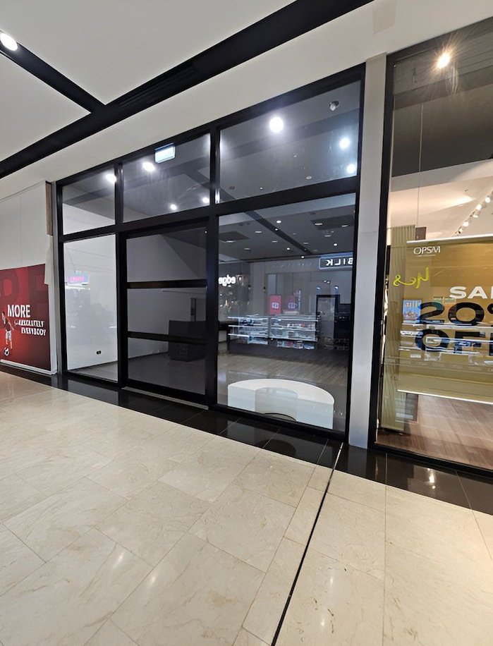 Empty Storefront With Black-framed Windows and a Closed Door in a Mall — Prestige Painting NT in Zuccoli, NT