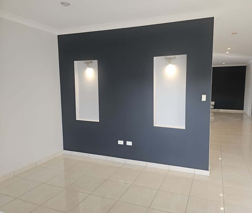 Empty Room With Dark Grey Accent Wall, Two Lighted Alcoves, and White Walls — Prestige Painting NT in Zuccoli, NT