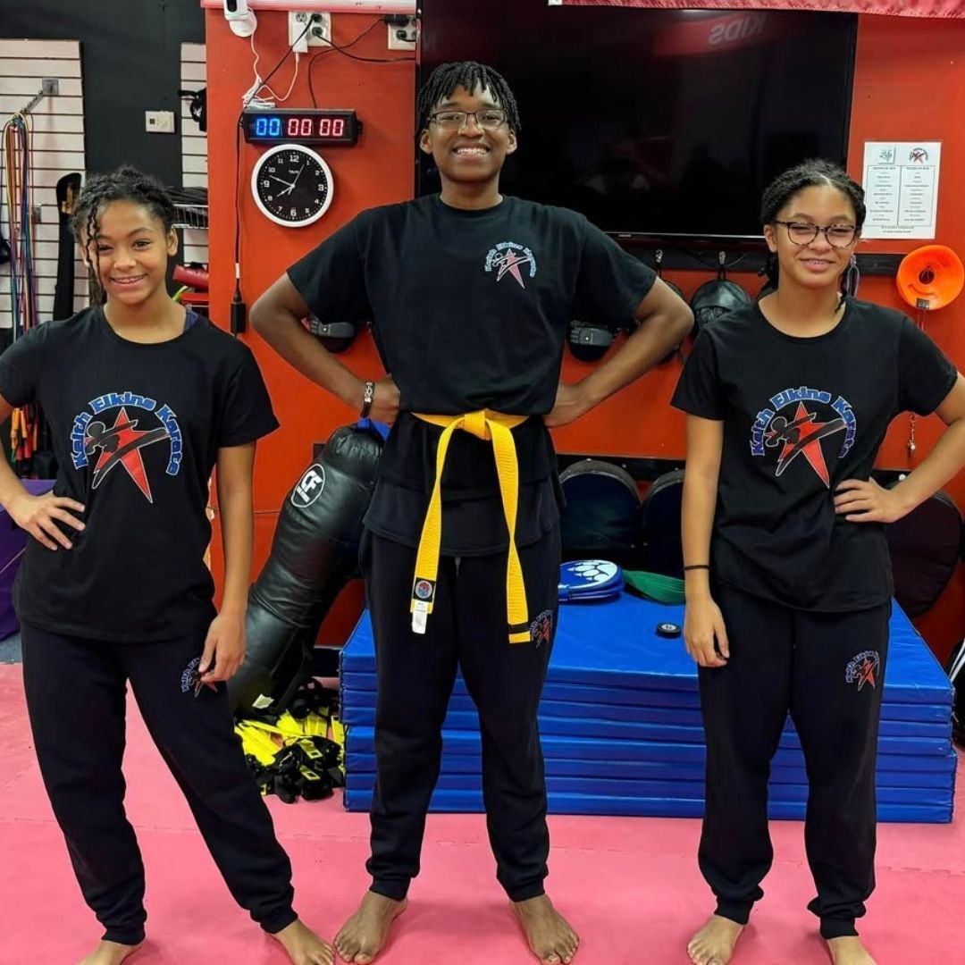 Two people practicing Brazilian Jiu-Jitsu on a mat; one in a black gi, one in a white gi, grappling.