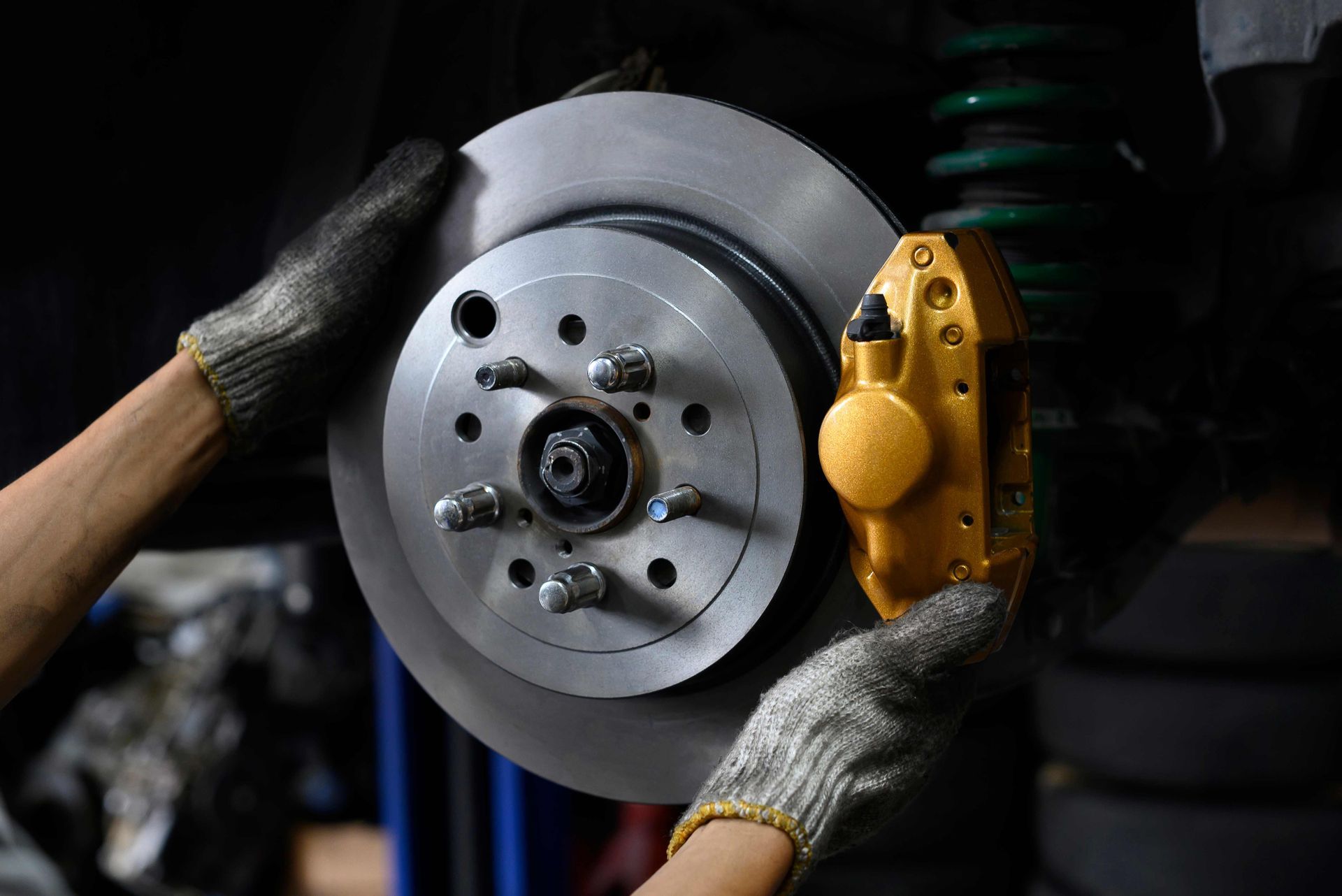 a person wearing gloves is working on a brake disc