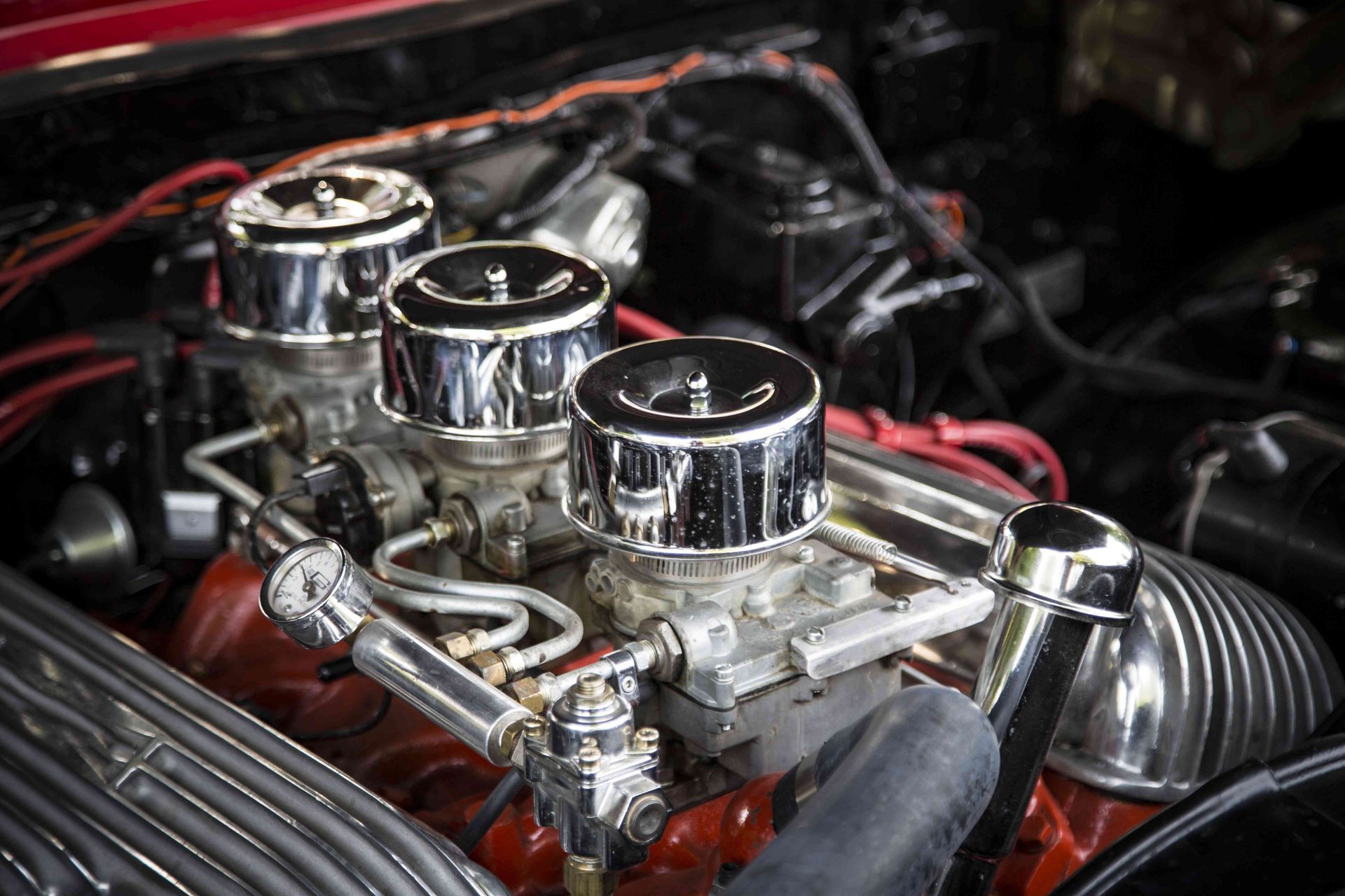 a close up of a car engine with chrome carburetors