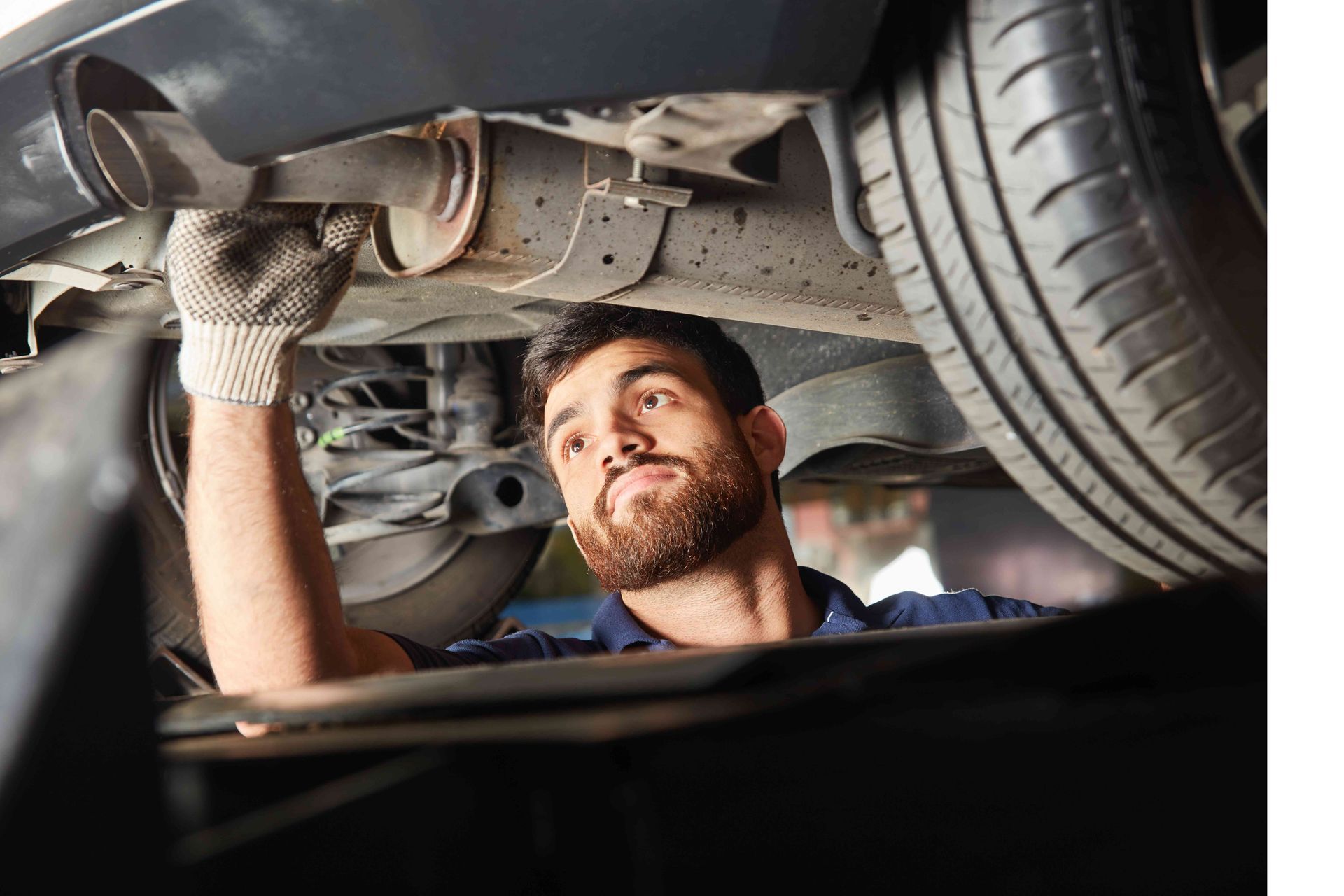 a man with a beard is working under a car