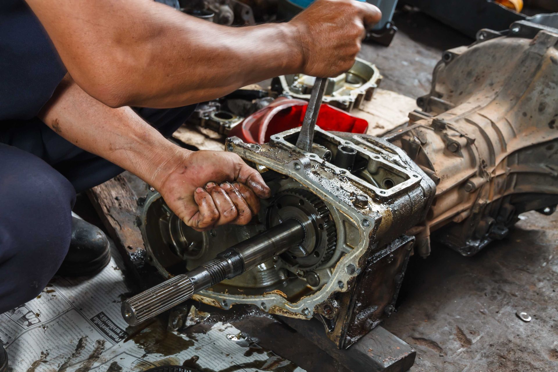 a man is working on a gearbox with a wrench