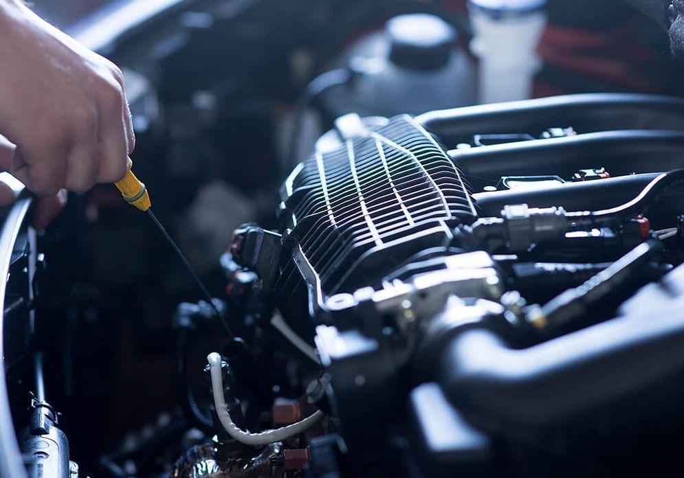 a person is checking the oil level of a car engine