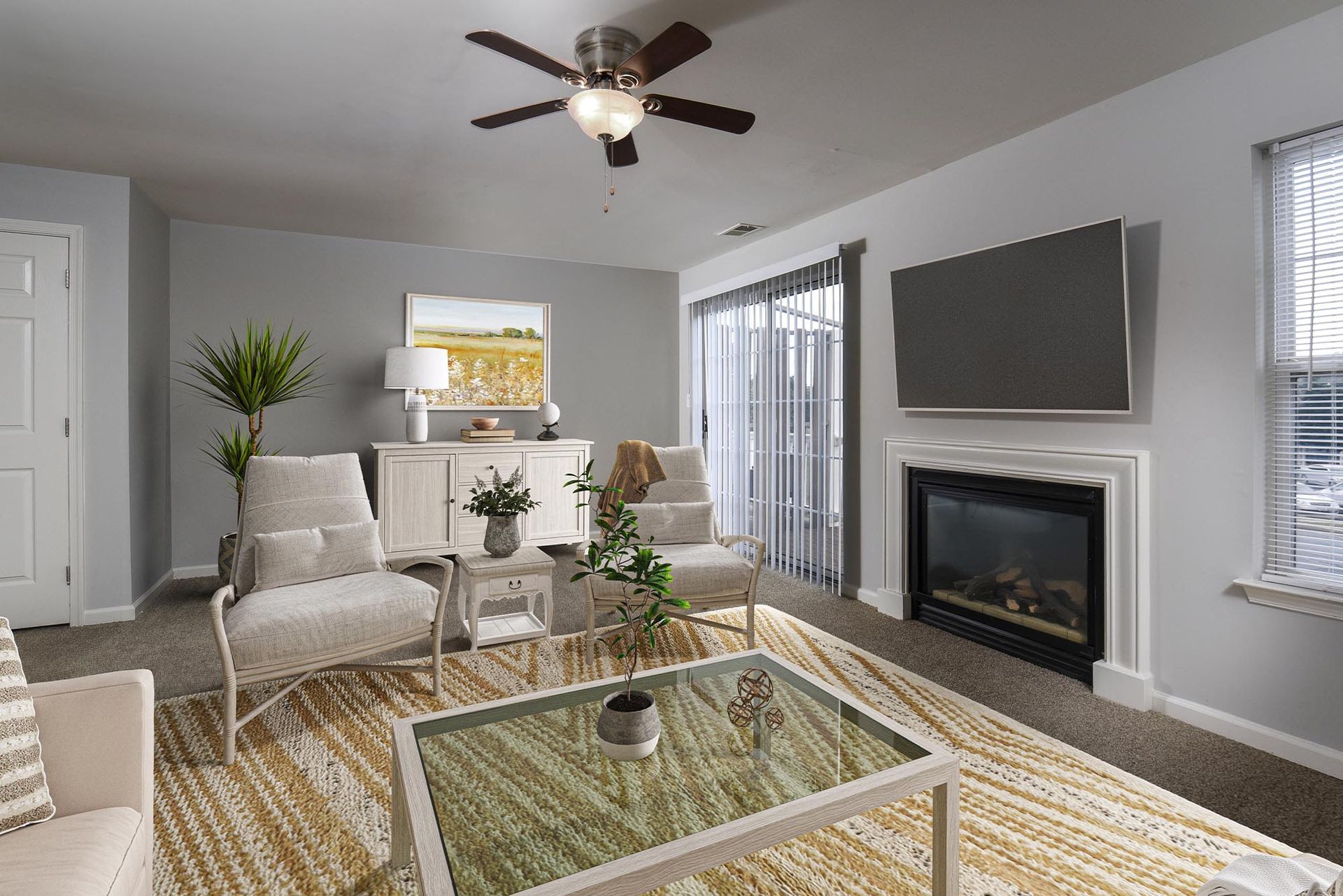 Living room in a furnished apartment with a fireplace, TV, ceiling fan, and sliding glass door.