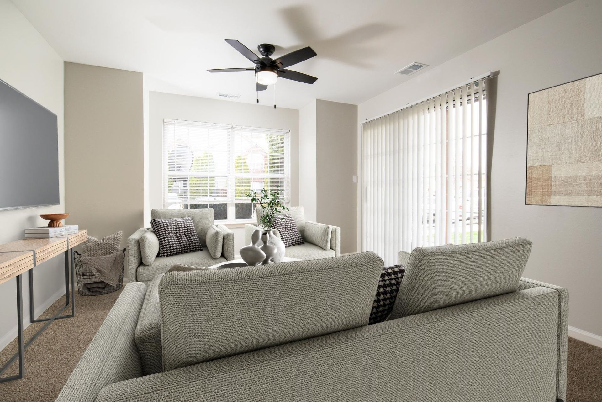 Bright living room in a modern apartment with beige sofas and large windows.