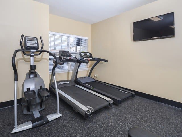 Fitness center with treadmills, an elliptical machine, and a wall-mounted TV.