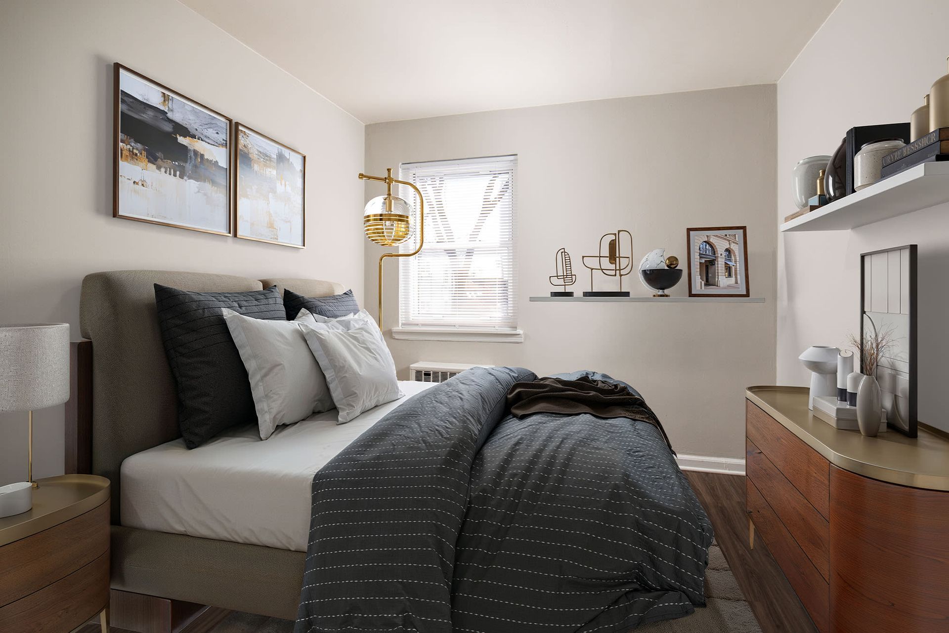Modern apartment bedroom with a bed, dresser, and window.
