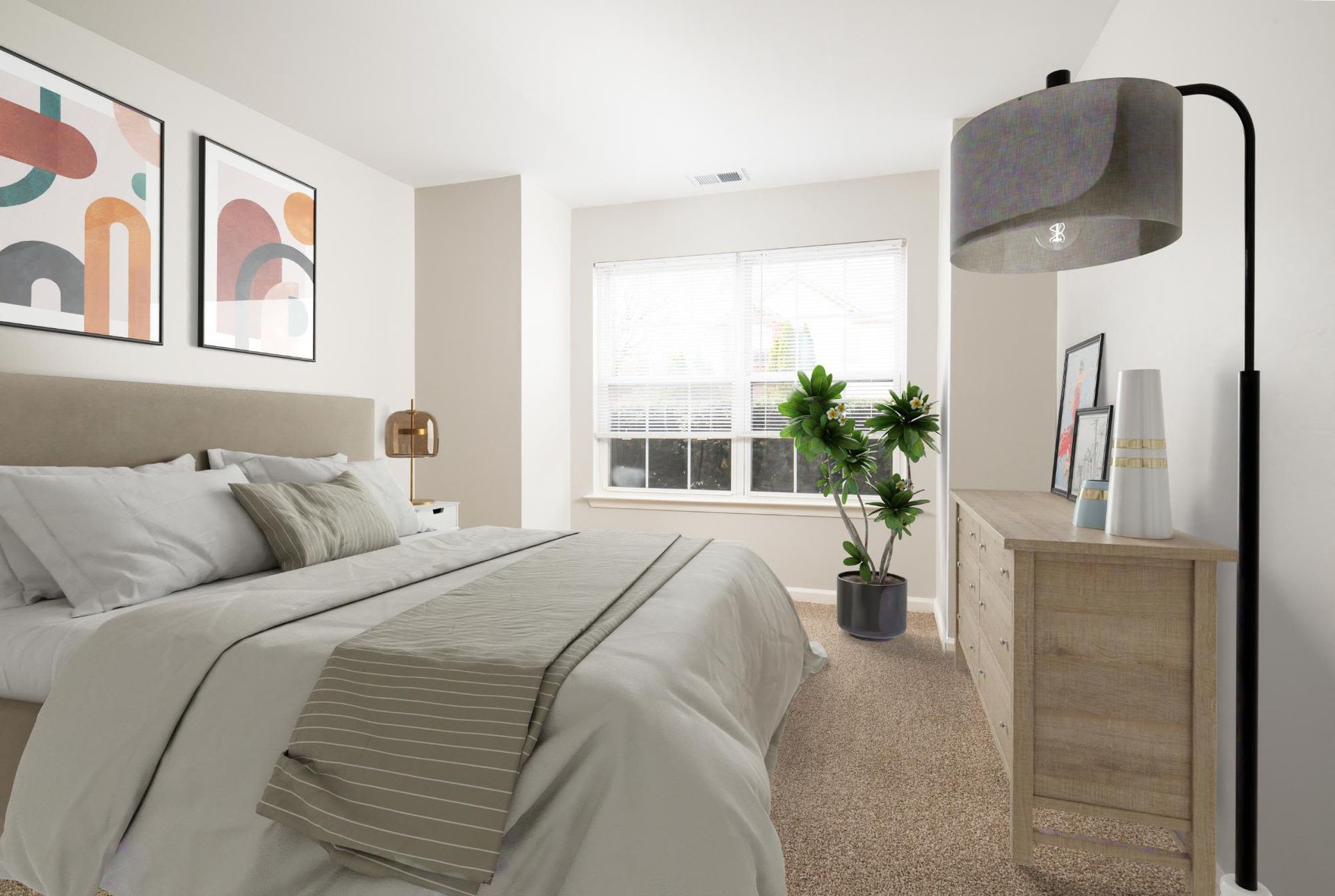 Bright bedroom with a beige upholstered headboard, white bedding, and a wooden dresser near a window.