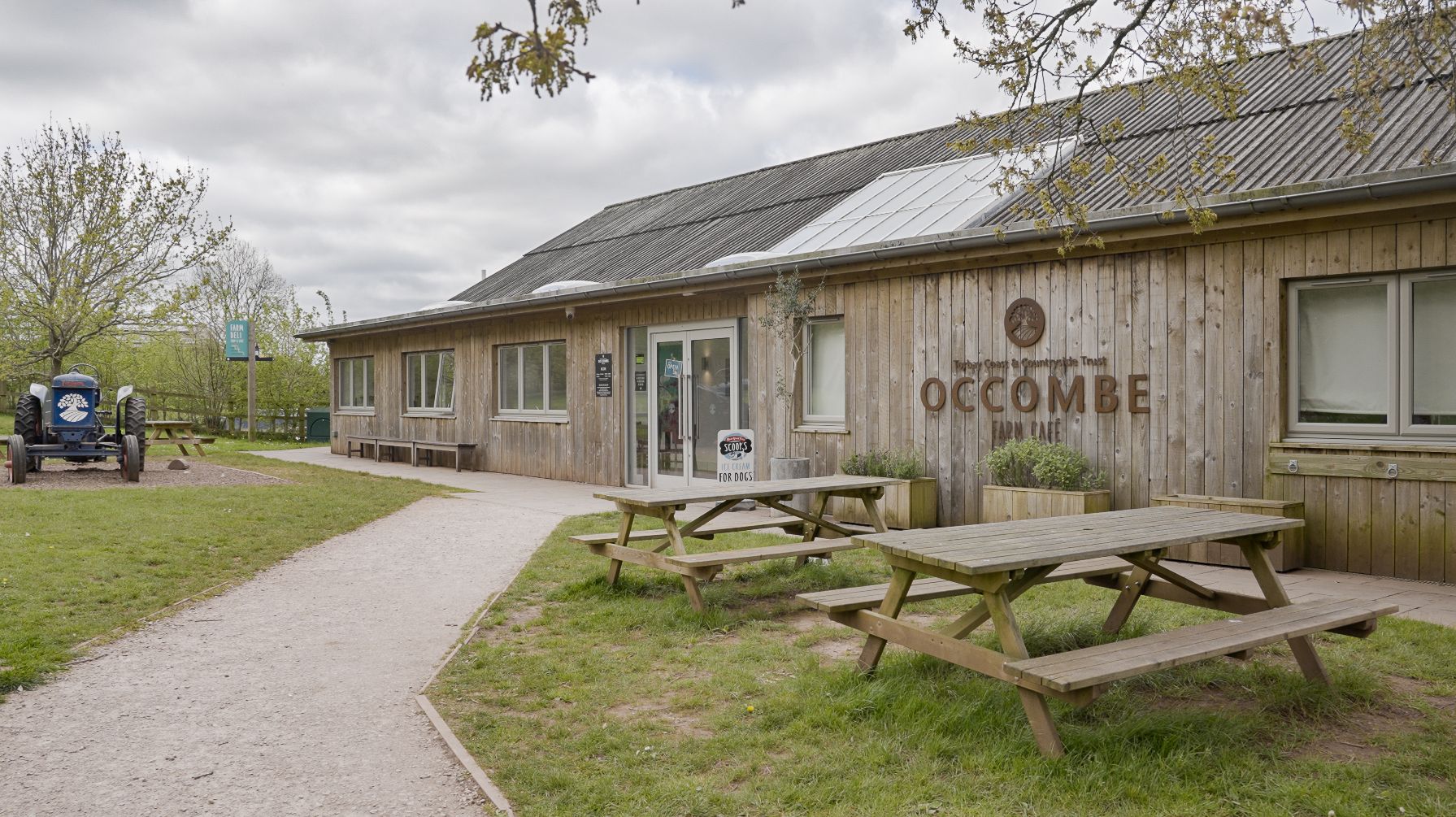 Occombe Farm Shop Exterior with Occombe Farm logo and benches