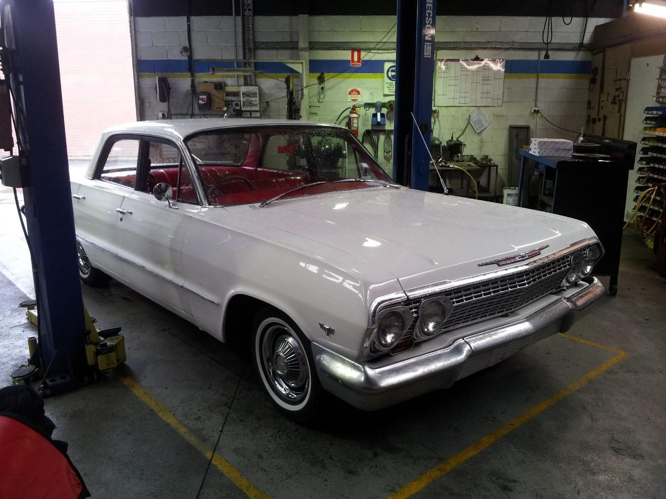 A White Car is Parked on a Lift in a Garage — Wodonga Brake & Clutch In Wodonga, VIC