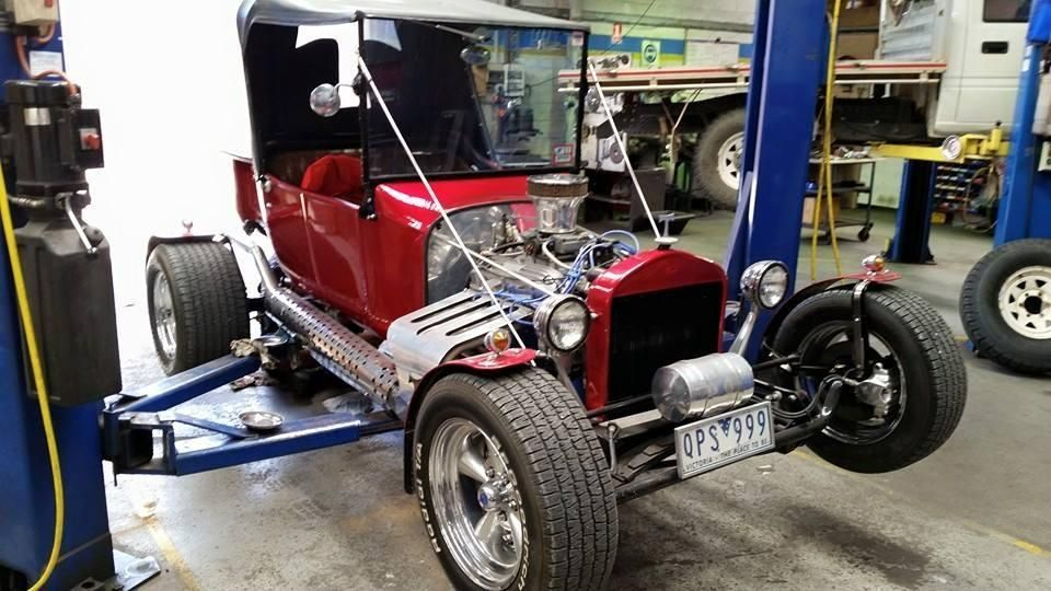 A Red Car is Sitting on a Lift in a Garage — Wodonga Brake & Clutch In Wodonga, VIC
