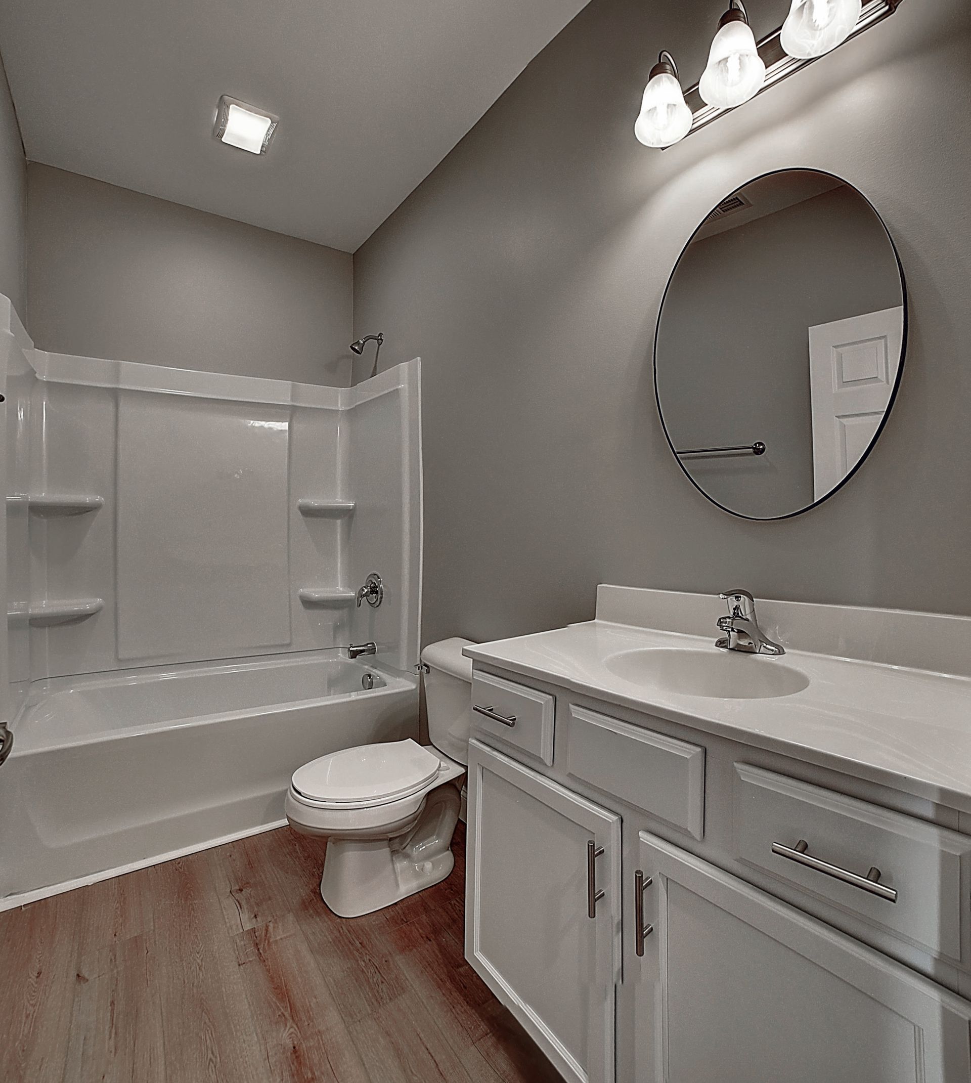 A bathroom with a toilet , sink , bathtub and mirror