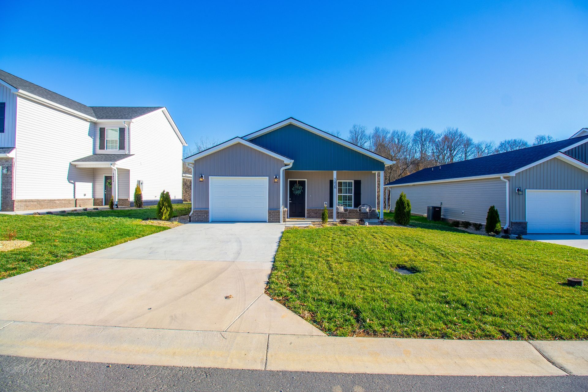 A house with a green roof is sitting next to another house in a residential area.
