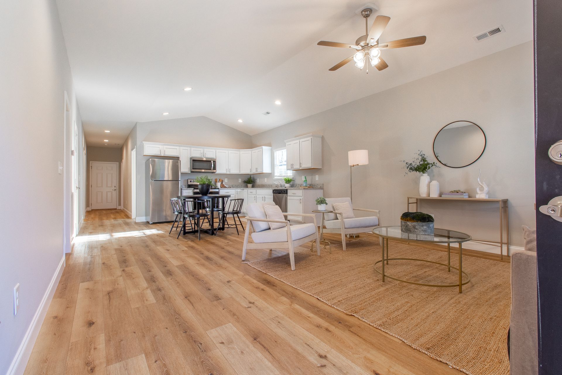 A living room with hardwood floors and a ceiling fan.