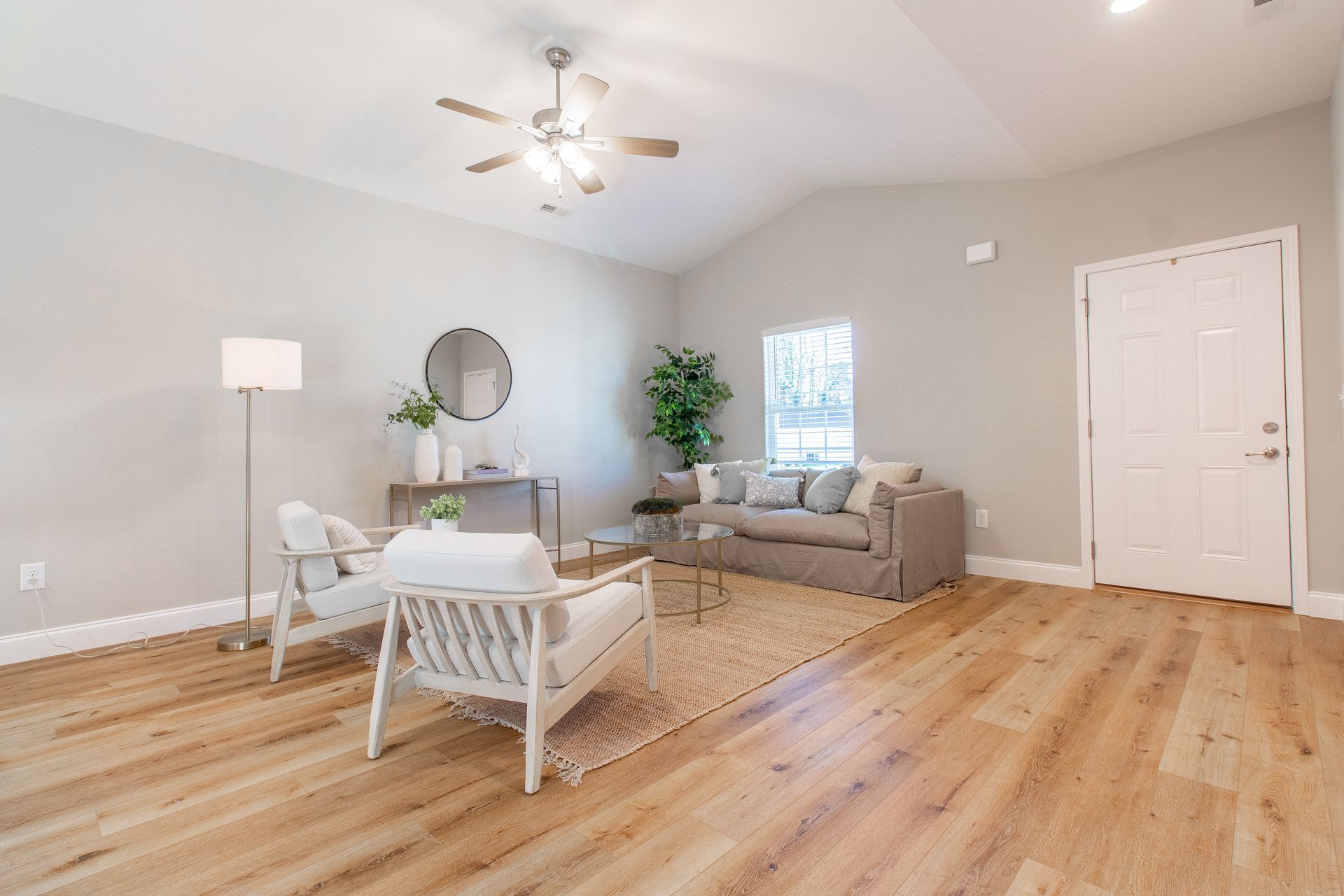 A living room with a couch , chairs , and a ceiling fan.