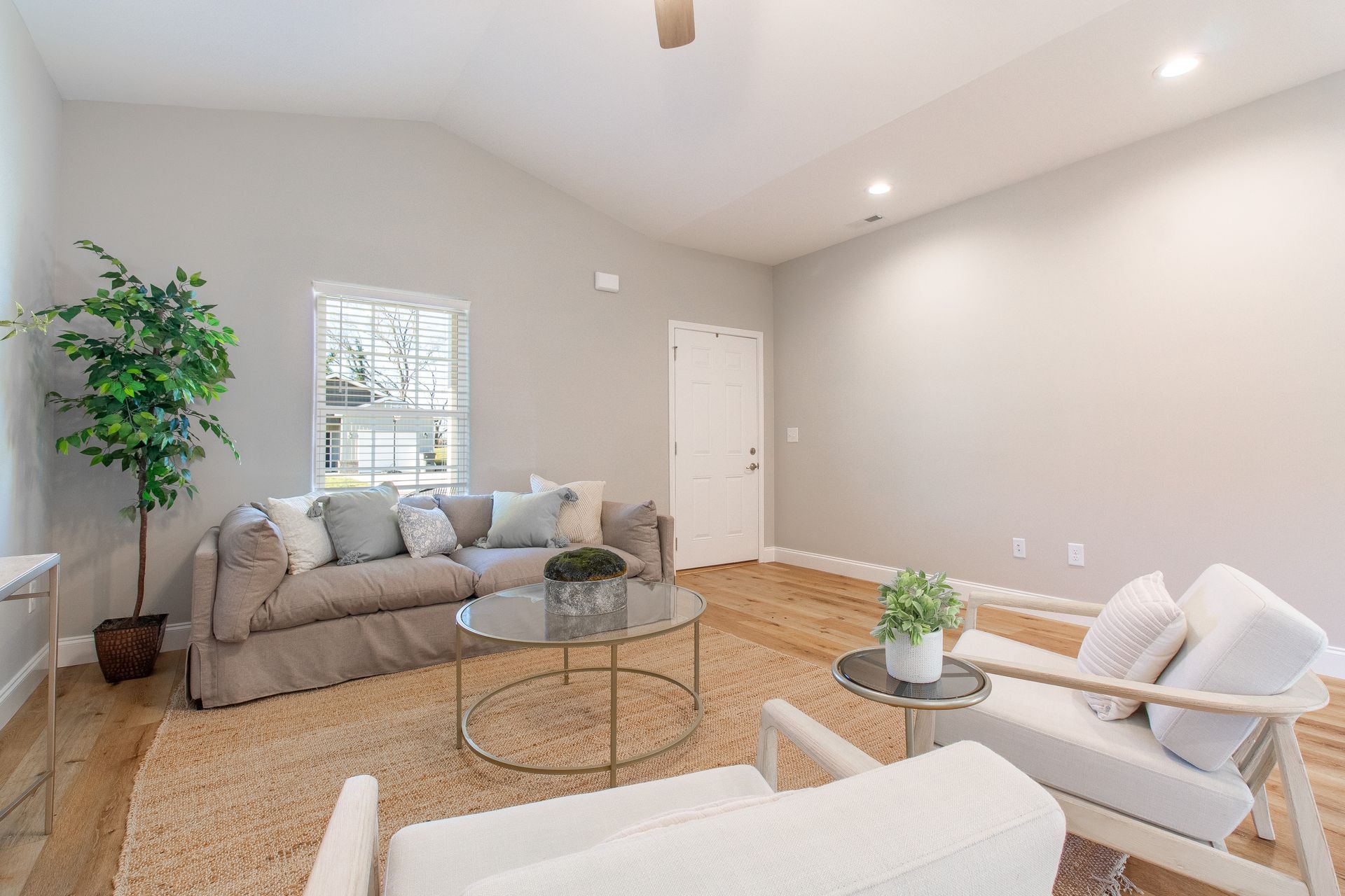 A living room with a couch , chairs , and a coffee table.