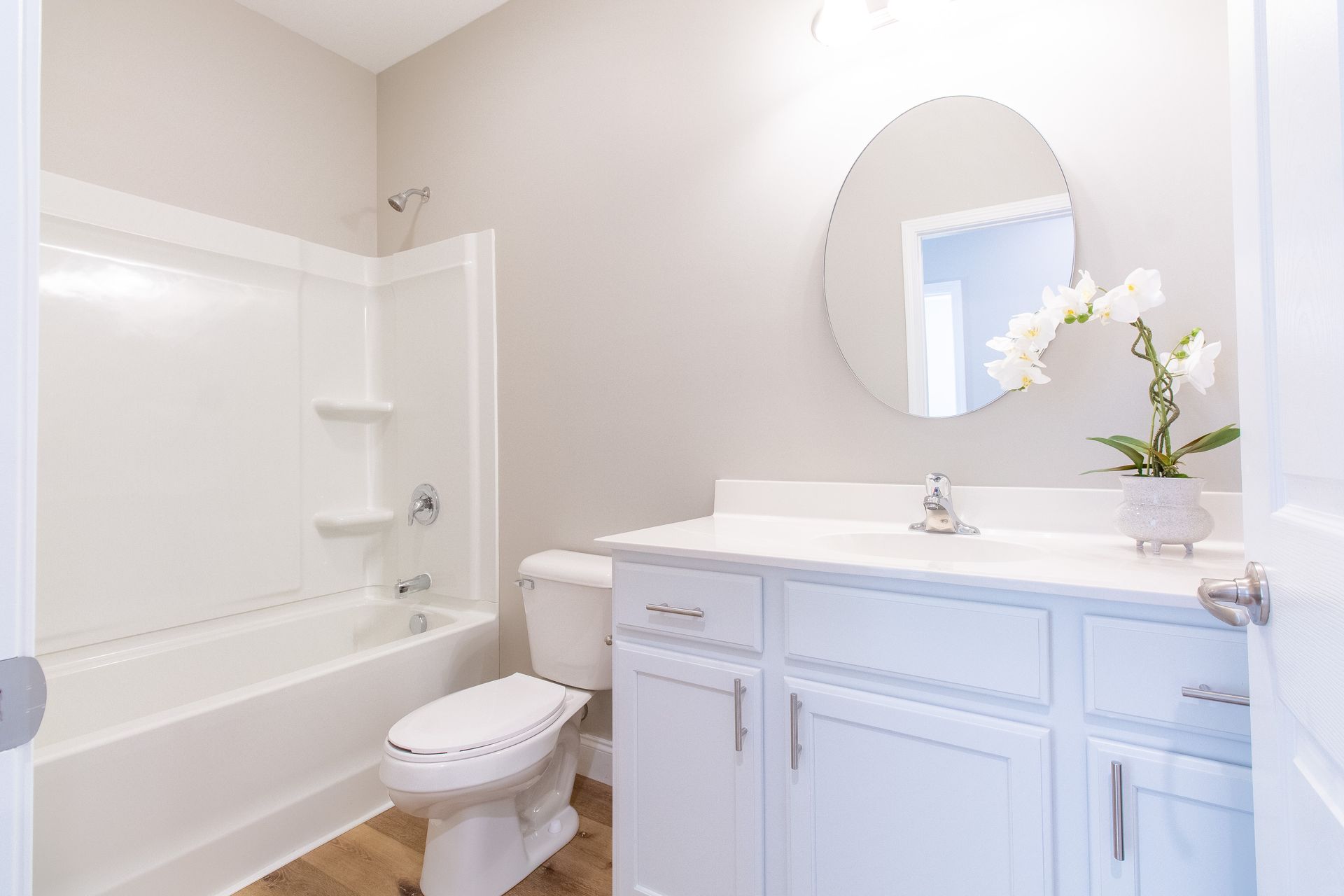A bathroom with a toilet , sink , bathtub and mirror.