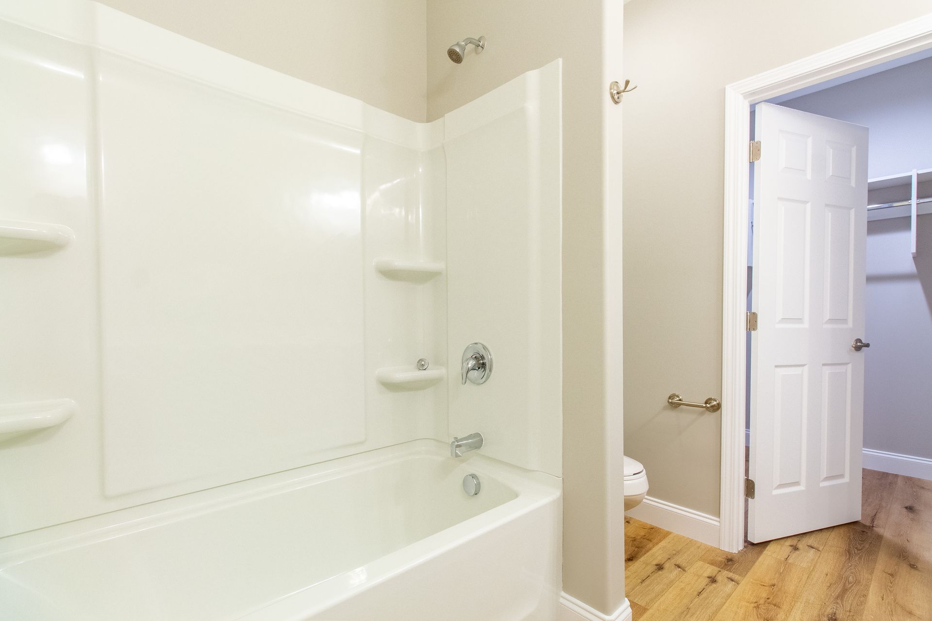 A bathroom with a bathtub , shower , toilet and walk in closet.