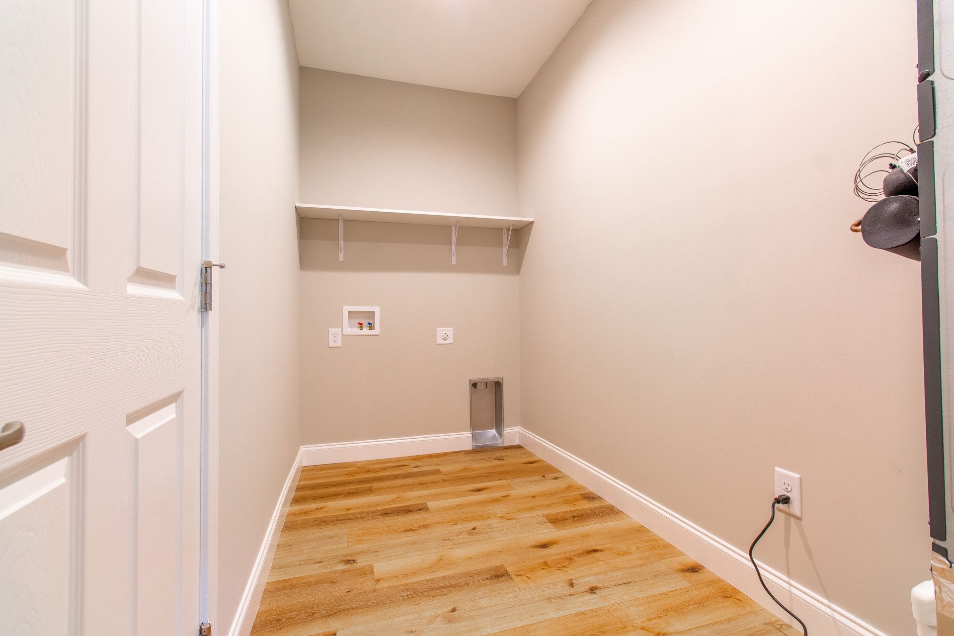 A laundry room with hardwood floors and a washer and dryer.