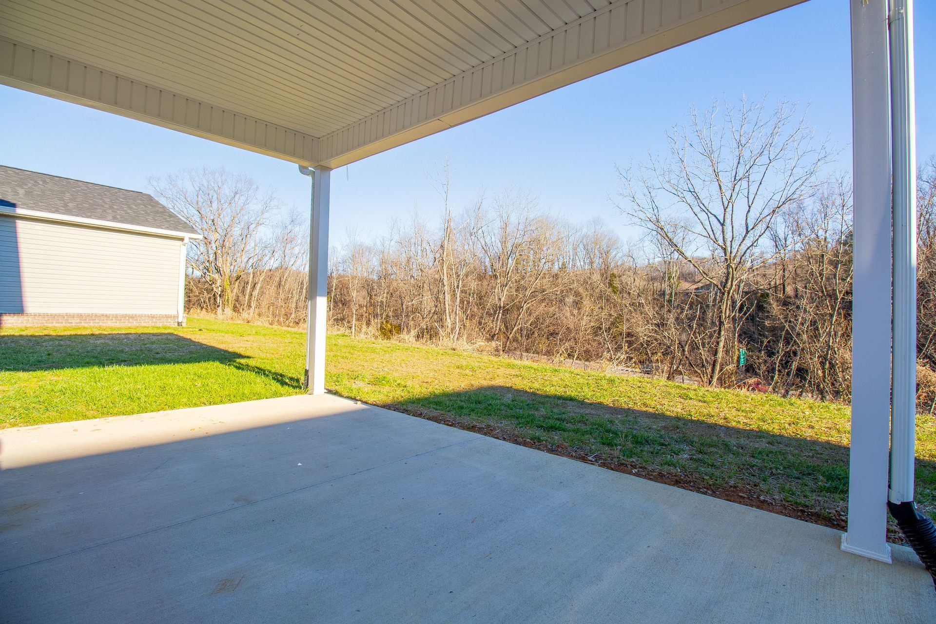 There is a covered patio in the backyard of a house.