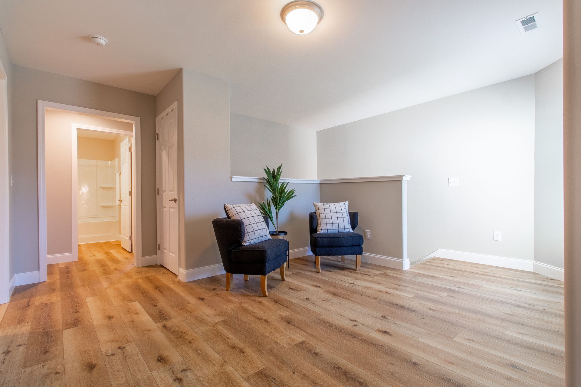 A living room with hardwood floors and two chairs.