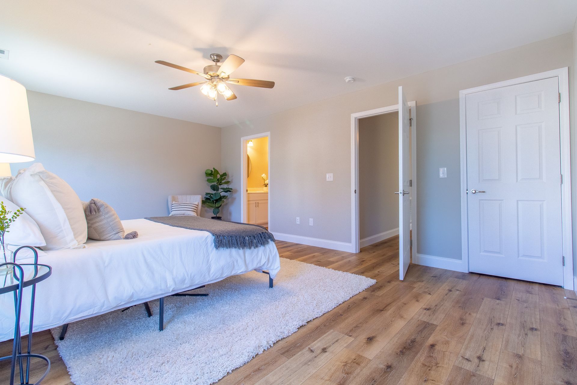 A bedroom with a bed and a ceiling fan.