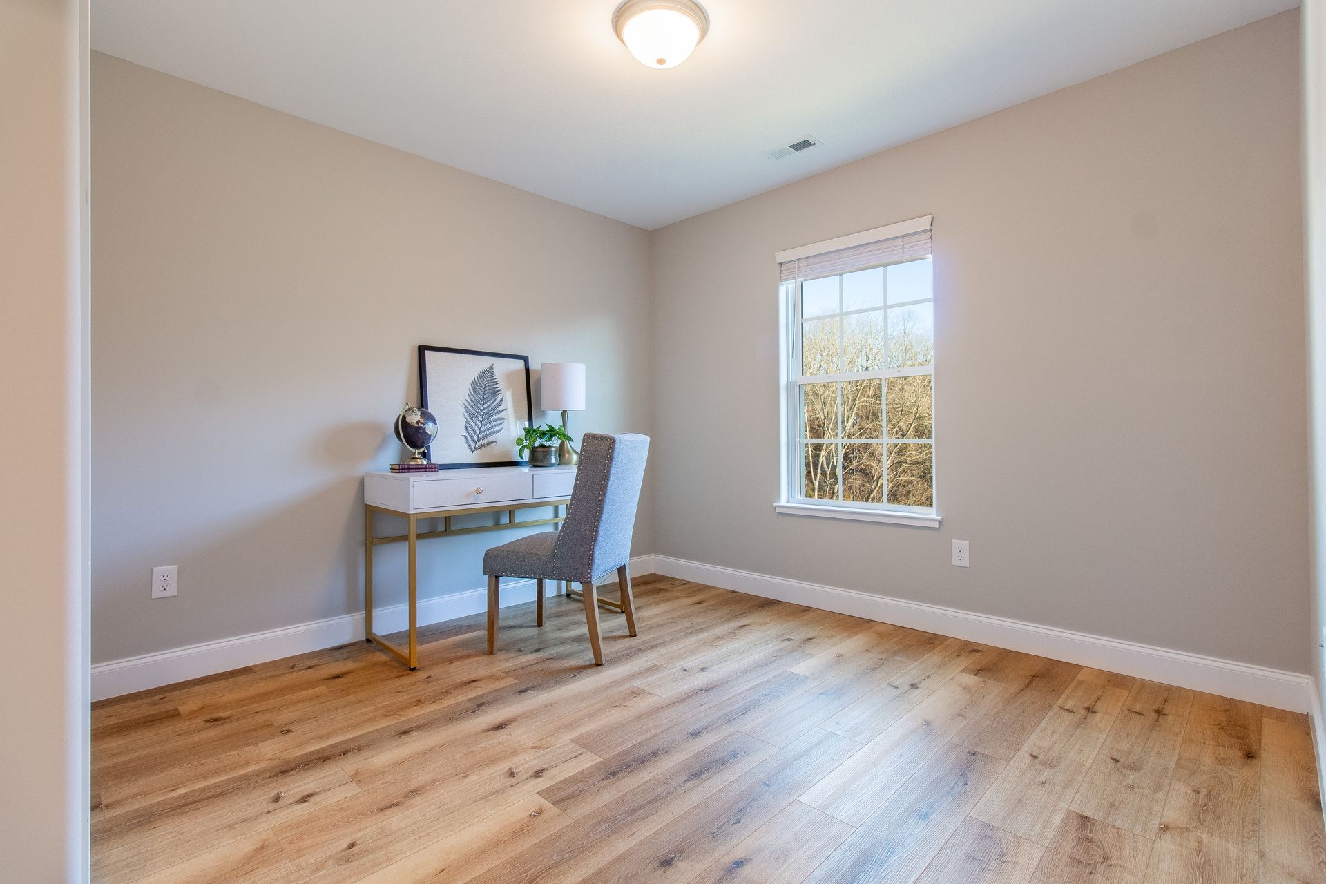There is a desk and chair in the middle of the room.