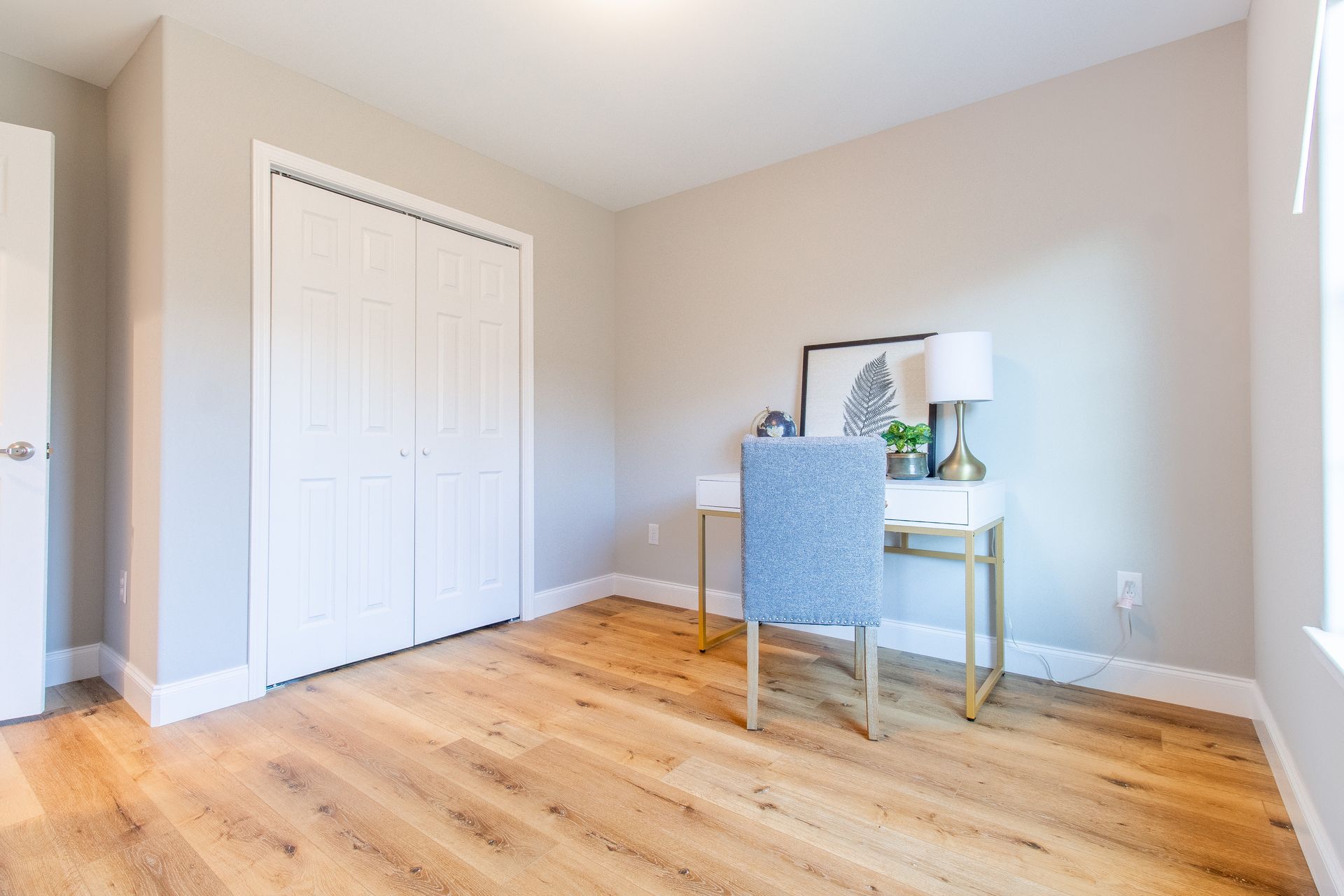 There is a desk and chair in the middle of the room.