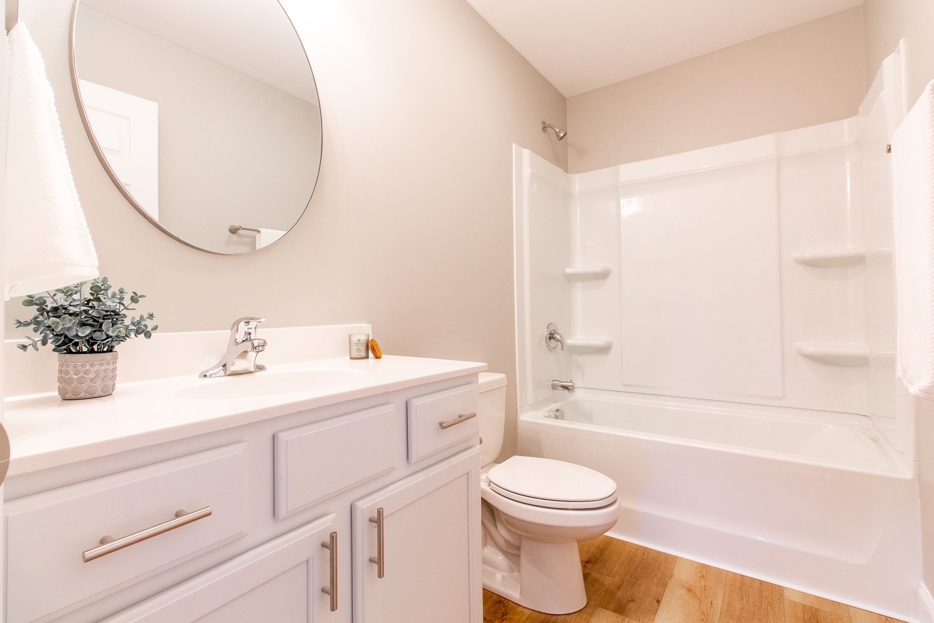 A bathroom with a sink , toilet , bathtub and mirror.