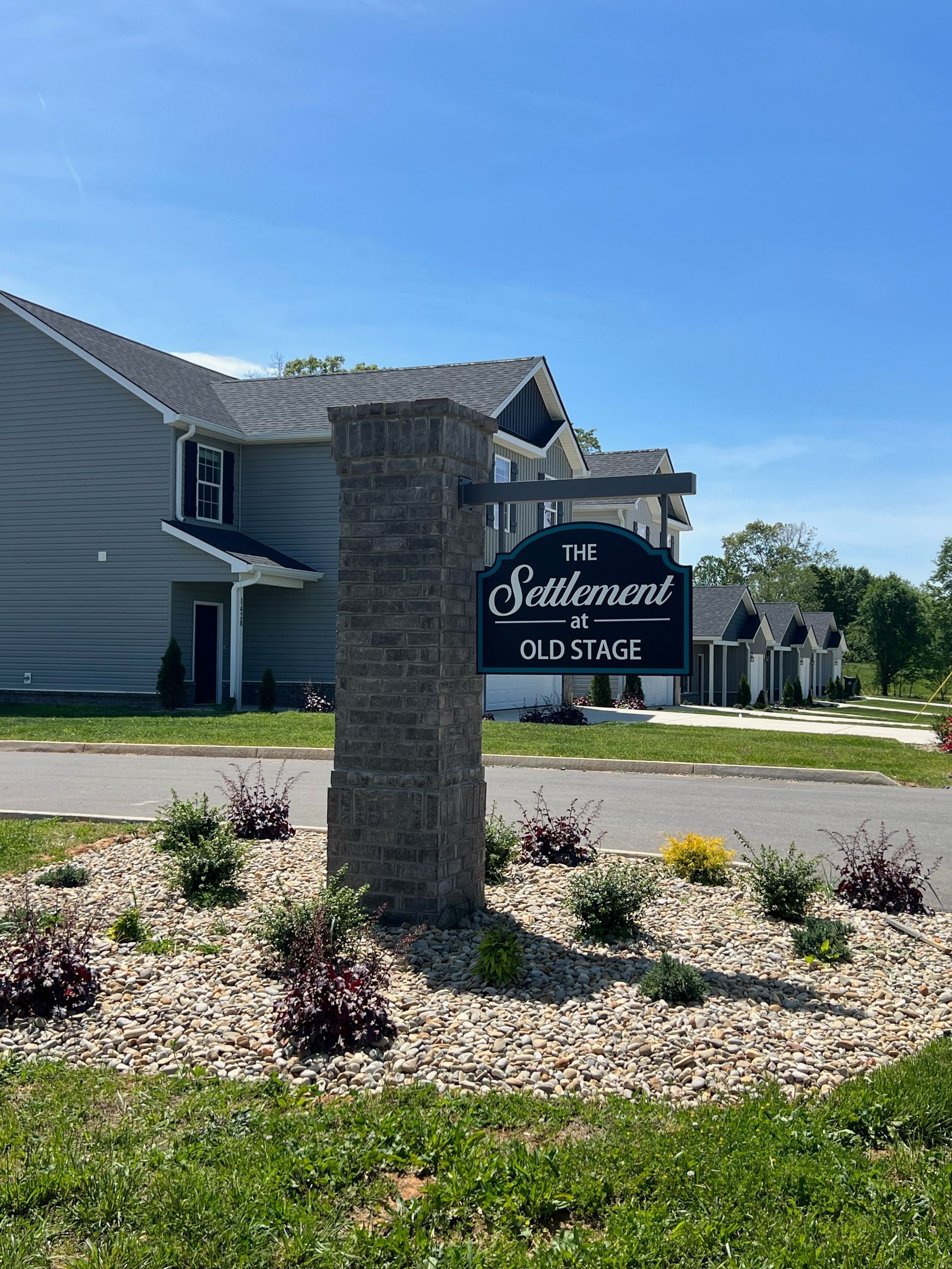 There is a sign in front of a house that says settlement old stage.