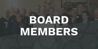 A group of people standing next to each other in front of a sign that says board members.