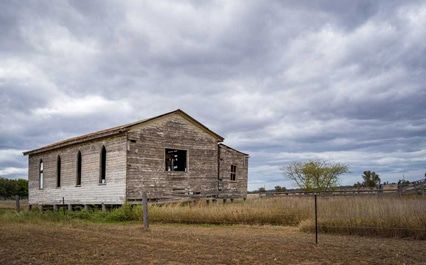 An Old Building In The Middle Of A Field With A Cloudy Sky In The Background — Brisbane Moving & Storage In Chinchilla, QLD