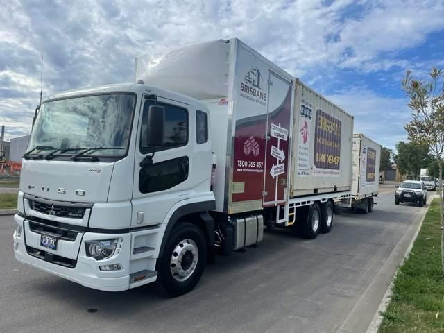 A Man And A Woman Are Holding Boxes And A Rug In Front Of A Car — Brisbane Moving & Storage In Acacia Ridge, QLD