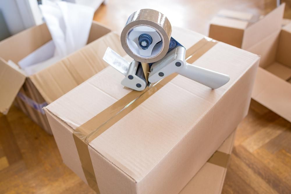 Cardboard Boxes With Packing Tape And Dispenser, On A Wooden Floor, Ready For Packing