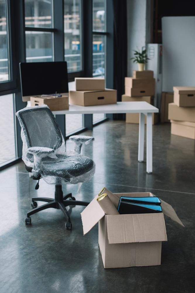 An Office With Boxes On The Floor And A Desk And Chair — Brisbane Moving & Storage In Acacia Ridge, QLD