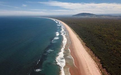 An Aerial View Of A Long Sandy Beach Next To The Ocean — Brisbane Moving & Storage In Miles, QLD