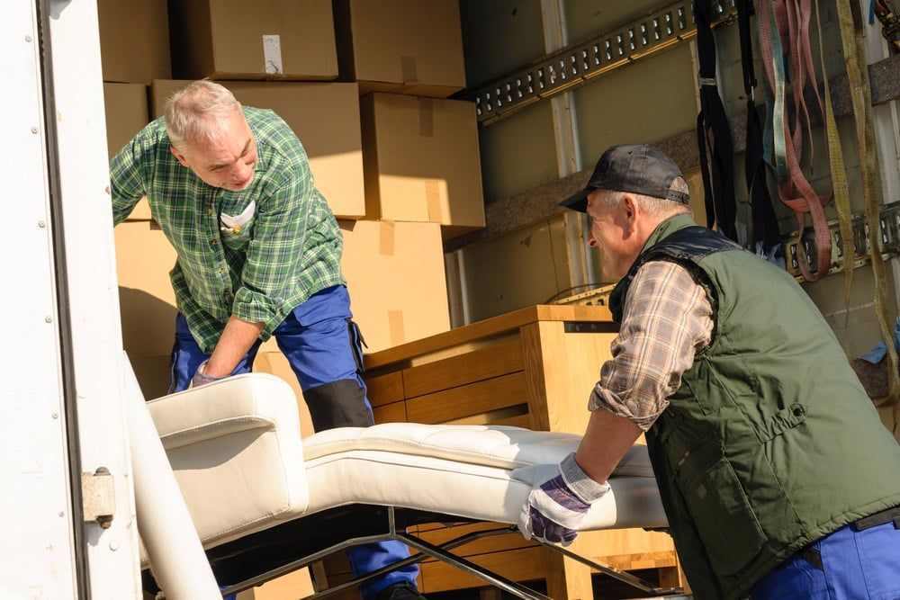 Two Men Are Loading A Couch Into A Truck — Brisbane Moving & Storage In Acacia Ridge, QLD