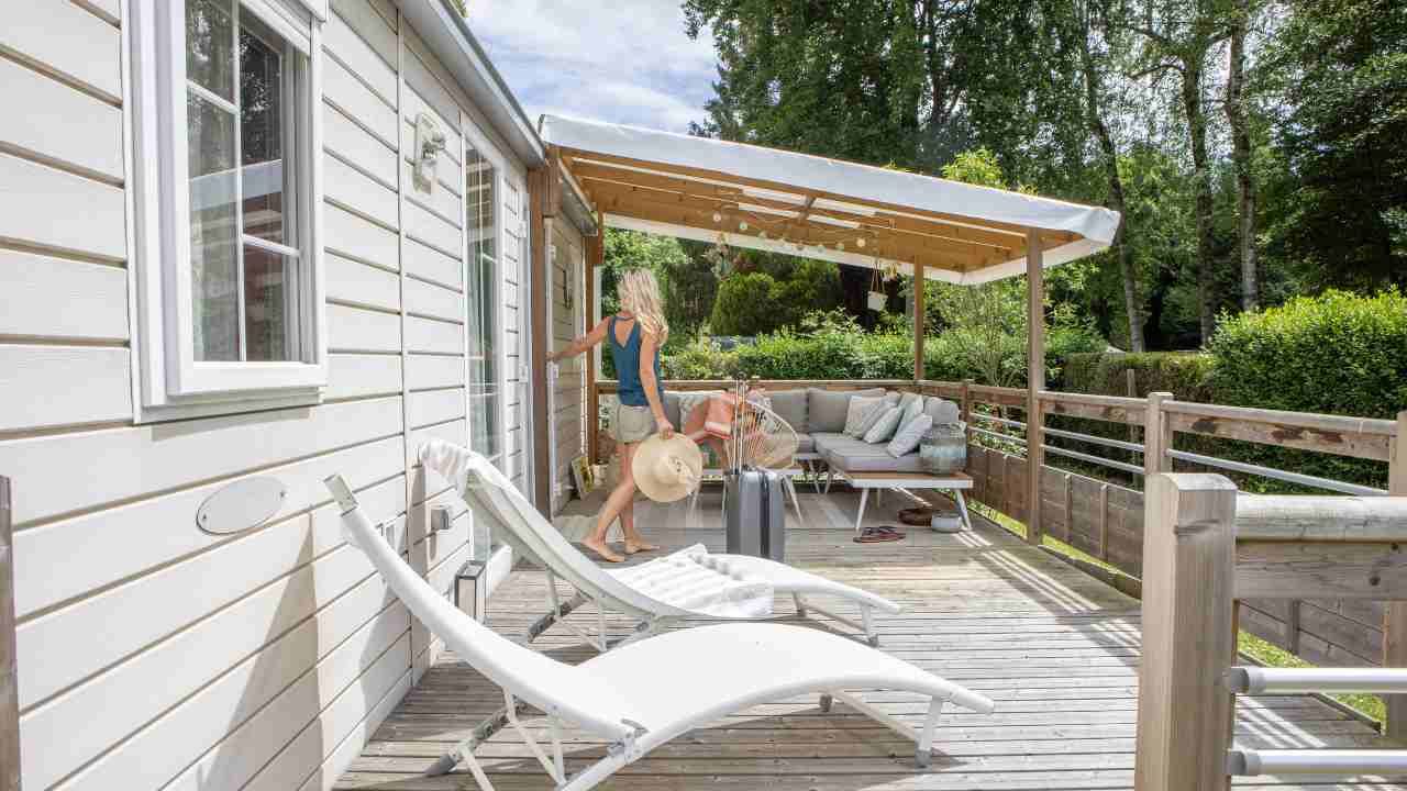 A woman is standing on the deck of a vacation home.