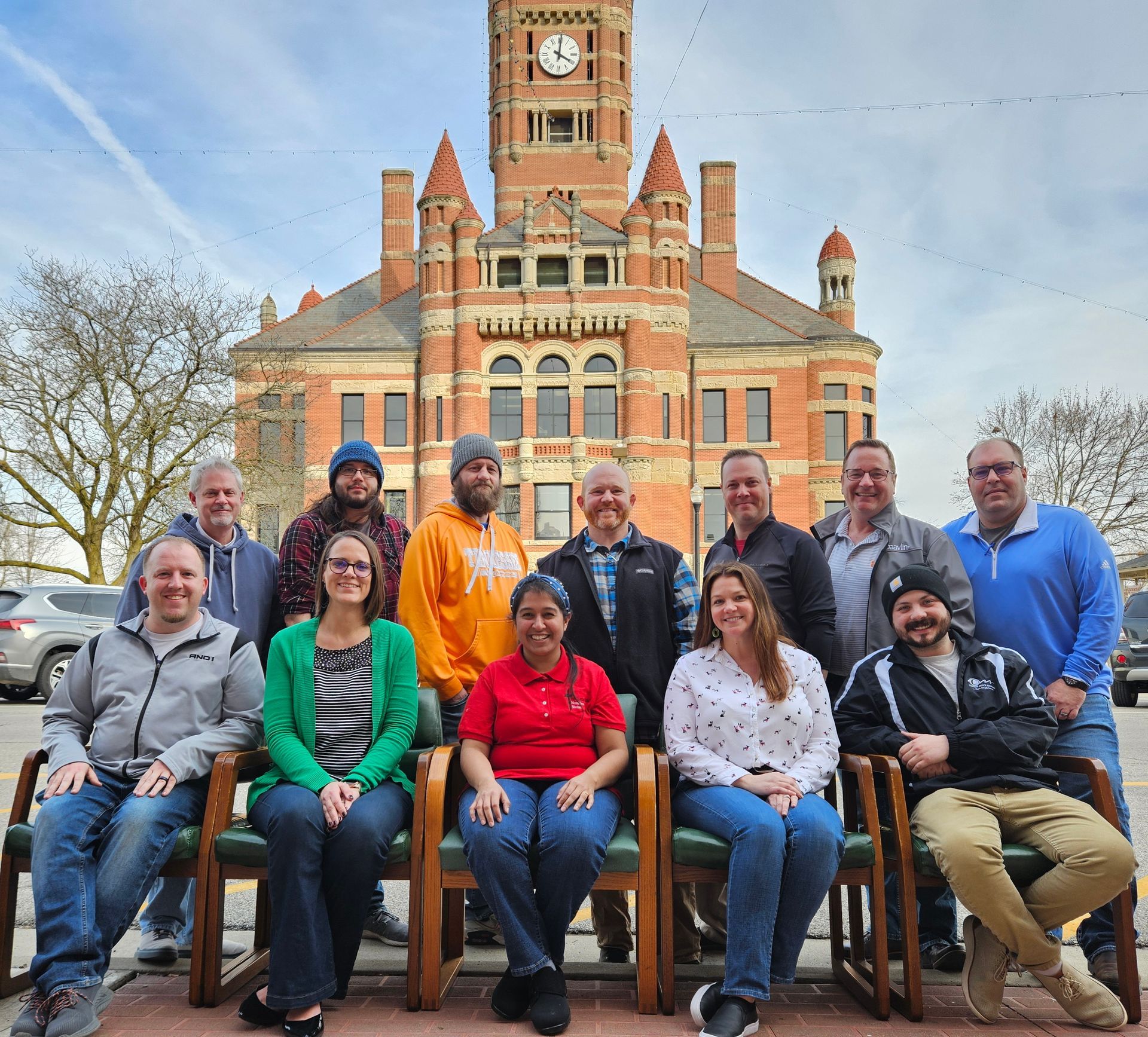 12 individuals sitting/standing in front of the Williams County Courthouse.